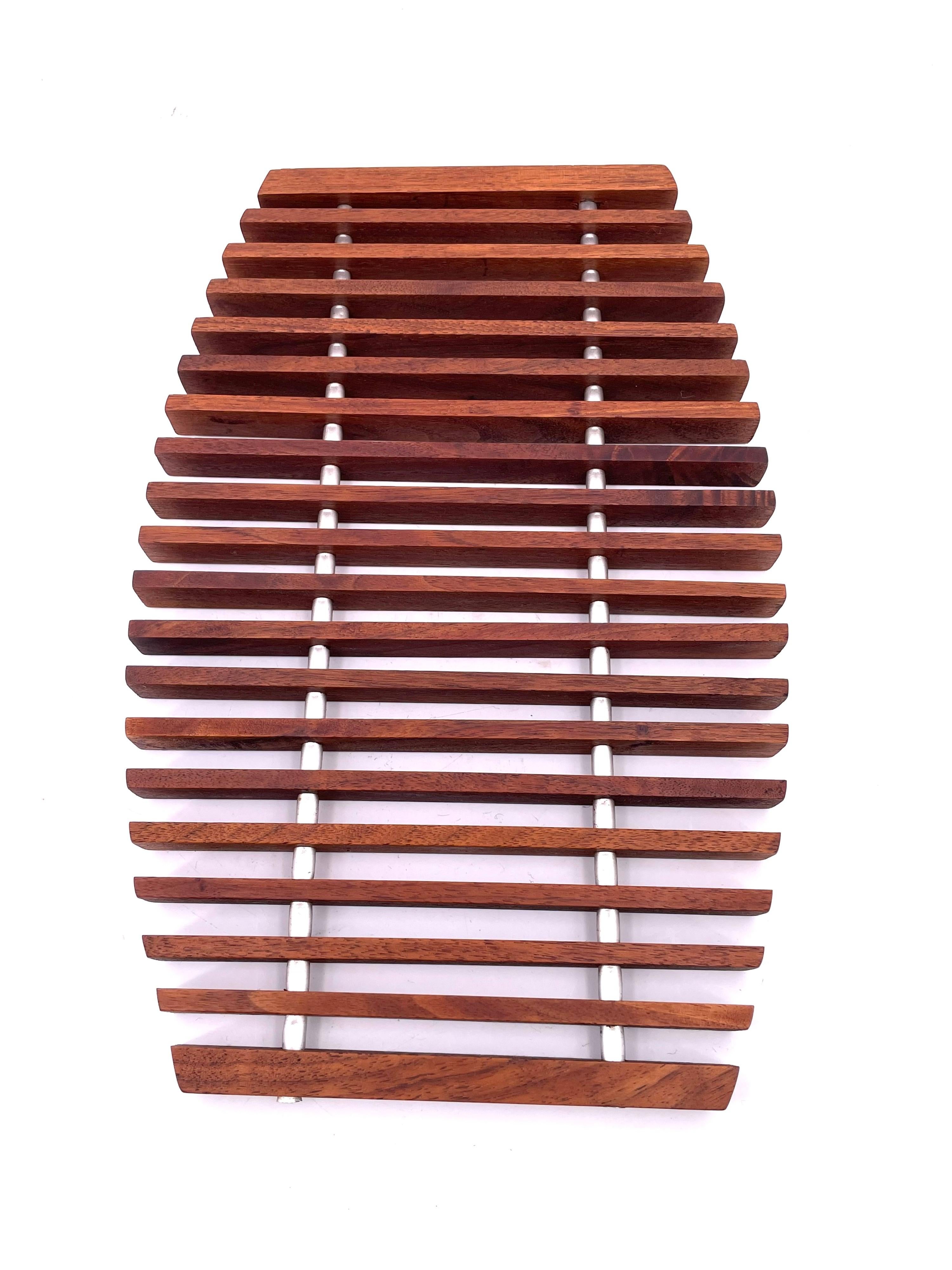 Beautiful solid teak rare trivet tray in solid teak with parallel aluminum rods that hold the bars in place, circa 1960's.