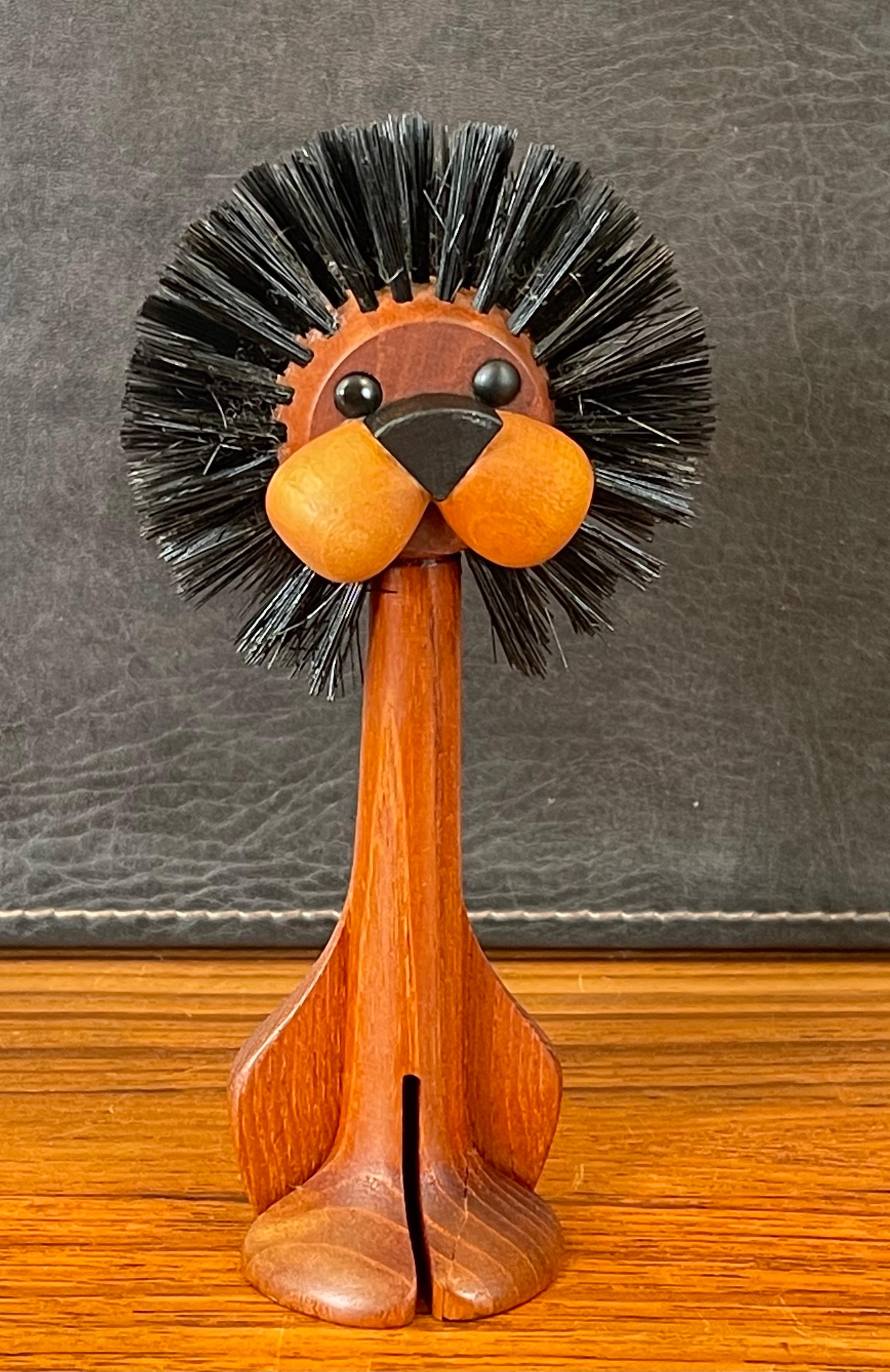 Danish modern solid teak carved lion toy / lint brush by Laurids Lonborg, circa 1950s. This incredibly fun lion lint brush was originally designed by Lonborg in Denmark and produced during the 1950's. Lonborg's animal figurines sit among the work of