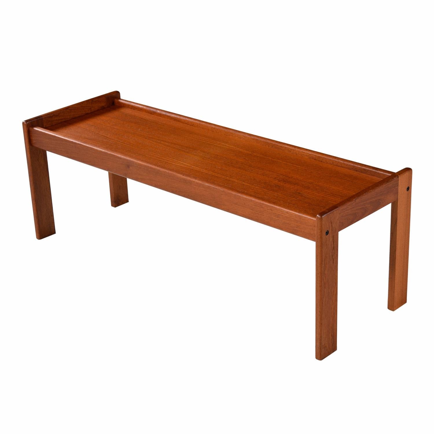 Scandinavian Modern Danish teak bench coffee table by Komfort. 100% solid teak in excellent in vintage condition. Perfectly suited for nearly any room. Removable, upholstered cushion allows this bench to double as a slender coffee table. 

Our