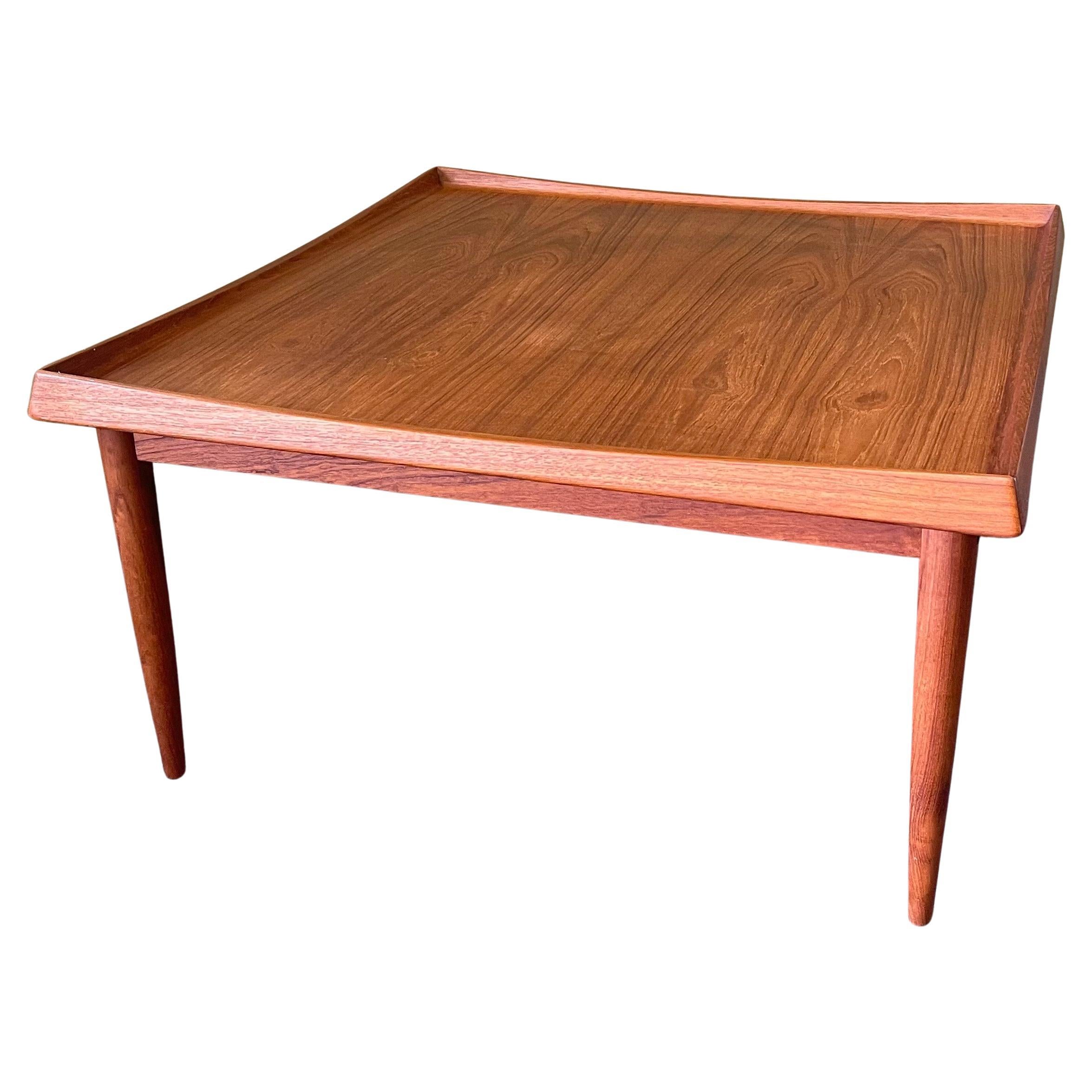 Gorgeous Danish modern solid teak coffee table by Moredo, circa 1960s. The table is in wonderful vintage condition with beautiful teak grain and measures 32