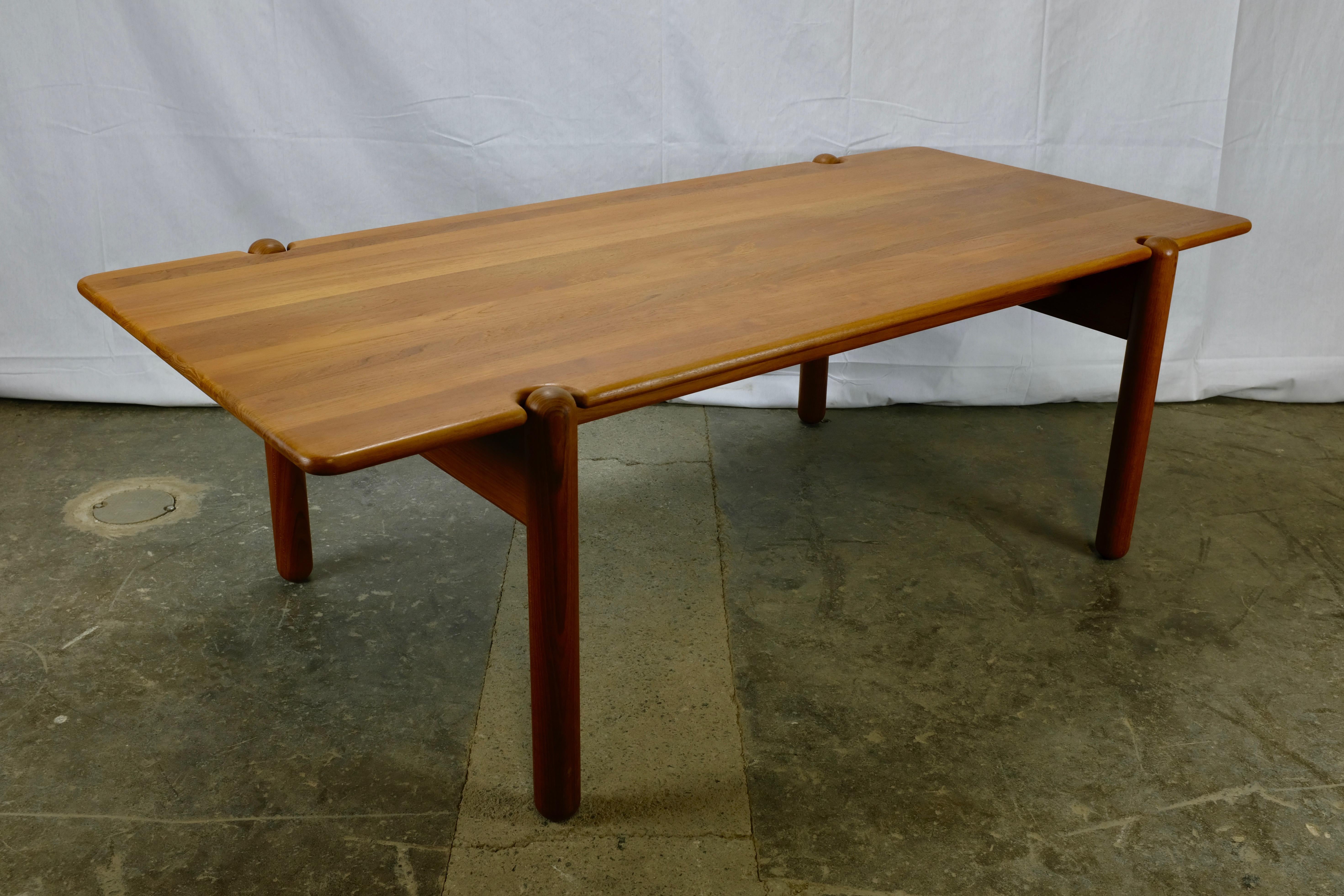 This Danish made coffee table features a solid teak top and the distinctive detail of round legs that project through the top. The length of the table makes it an excellent piece to anchor a living room in front of a sofa.

The top features a