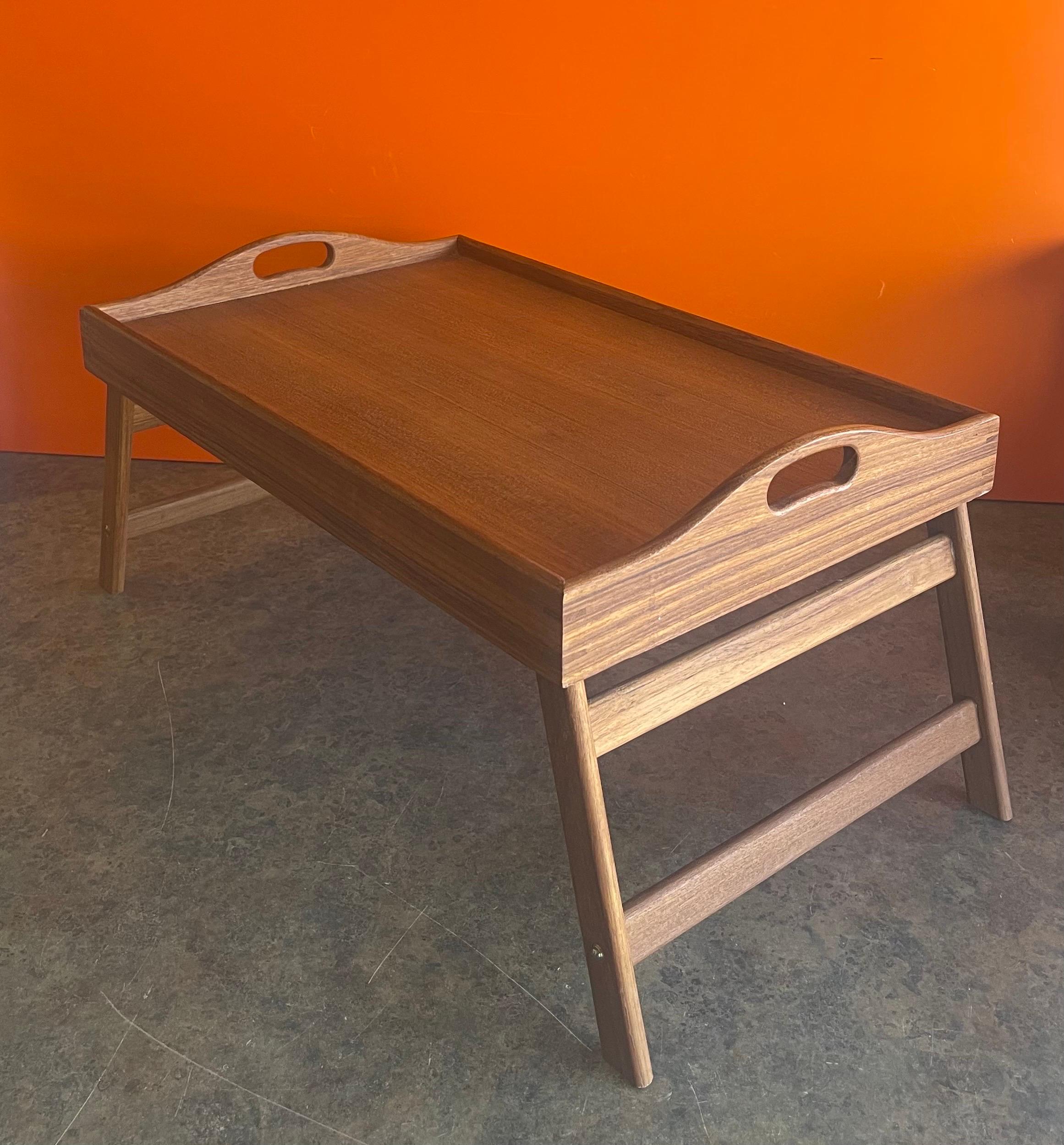 Versatile Danish modern folding teak bed / breakfast tray, circa 1980s. The tray can be used for breakfast in bed with the two foldable legs or as a regular serving tray with the legs in the up position. The piece is in very good vintage condition