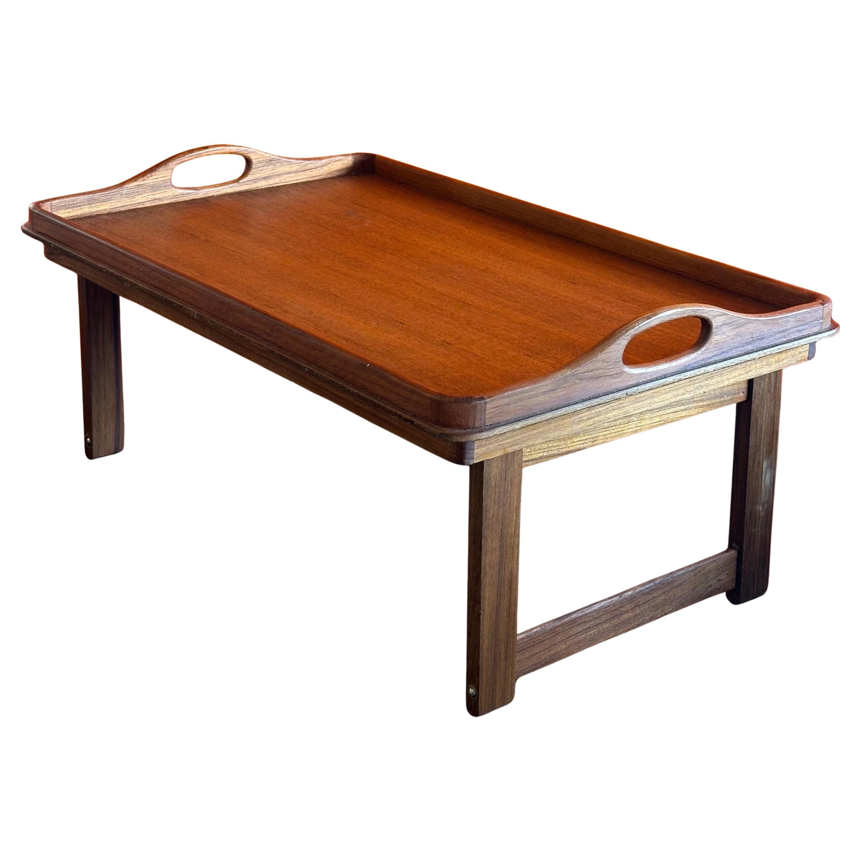 Versátil bandeja plegable danesa moderna de teca para cama/desayuno, hacia la década de 1980. La bandeja puede utilizarse para desayunar en la cama con las dos patas plegables o como bandeja normal para servir con las patas en posición elevada. La