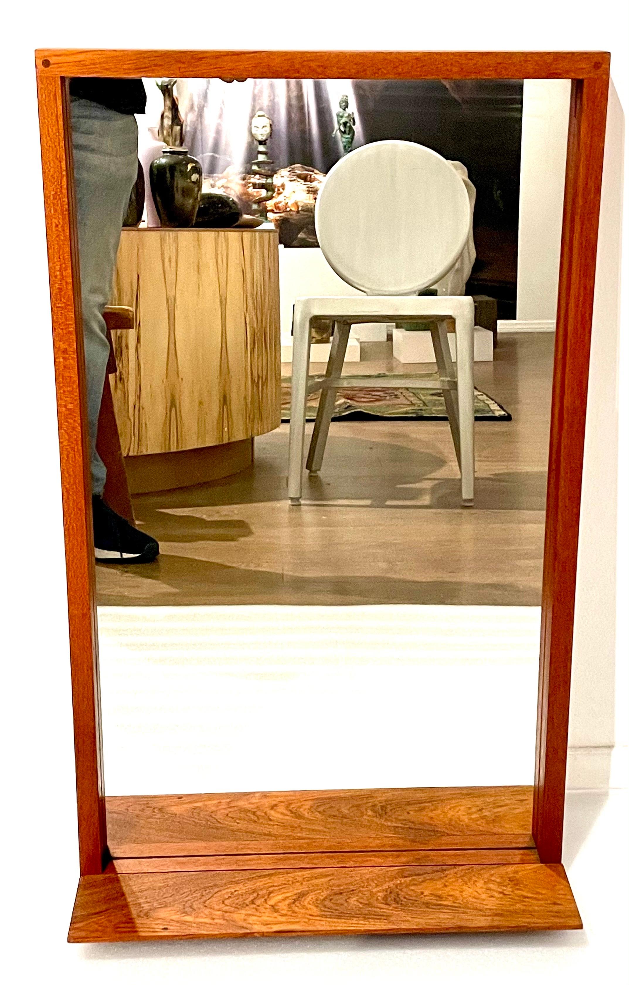A beautiful solid teak dovetail mirror with a shelf, the bottom shelf, that can be removed. beautiful craftsmanship light and easy to hang.