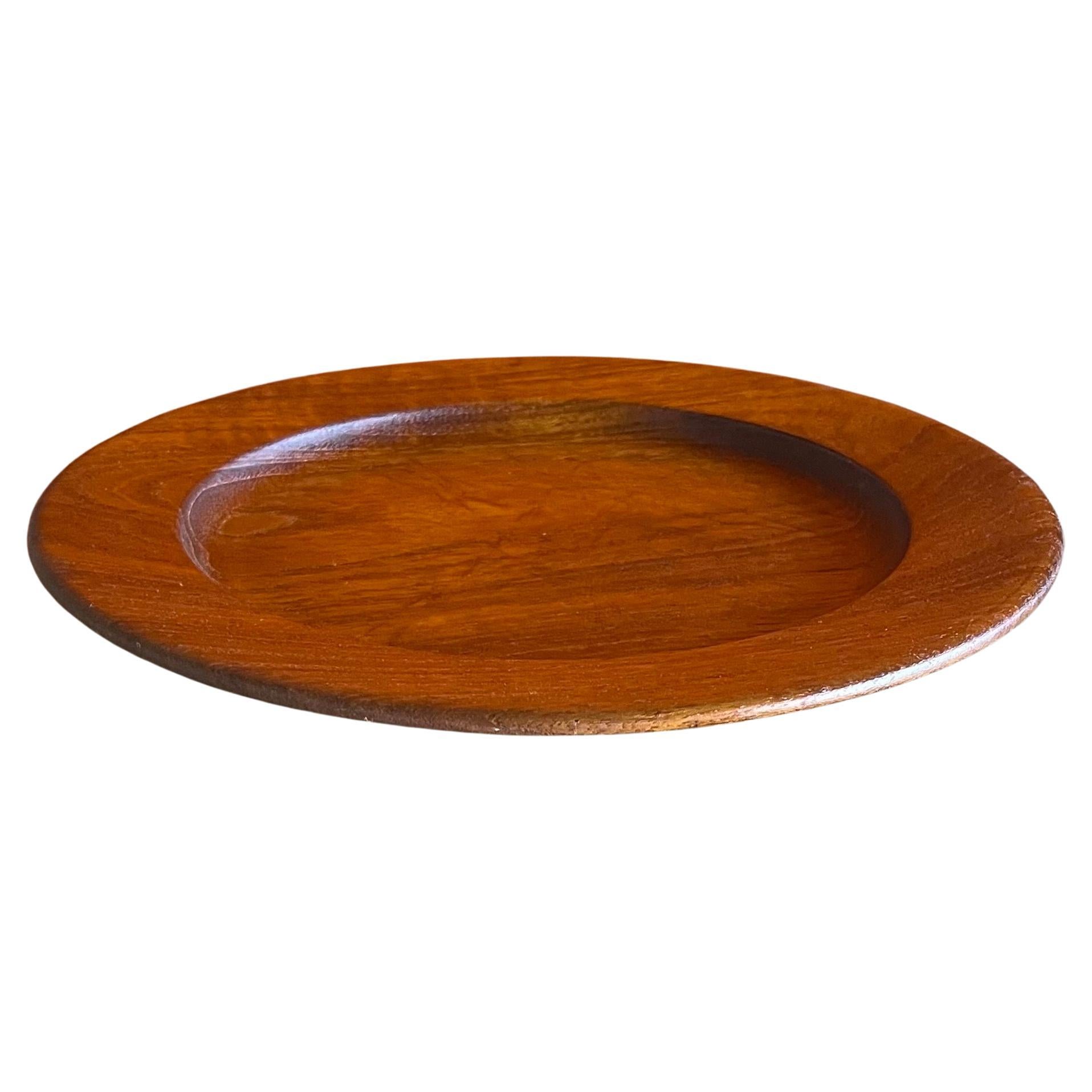 A Danish modern solid teak serving plate by Kay Bojesen, circa 1950s.  The plate is in good vintage condition and measures 10.75