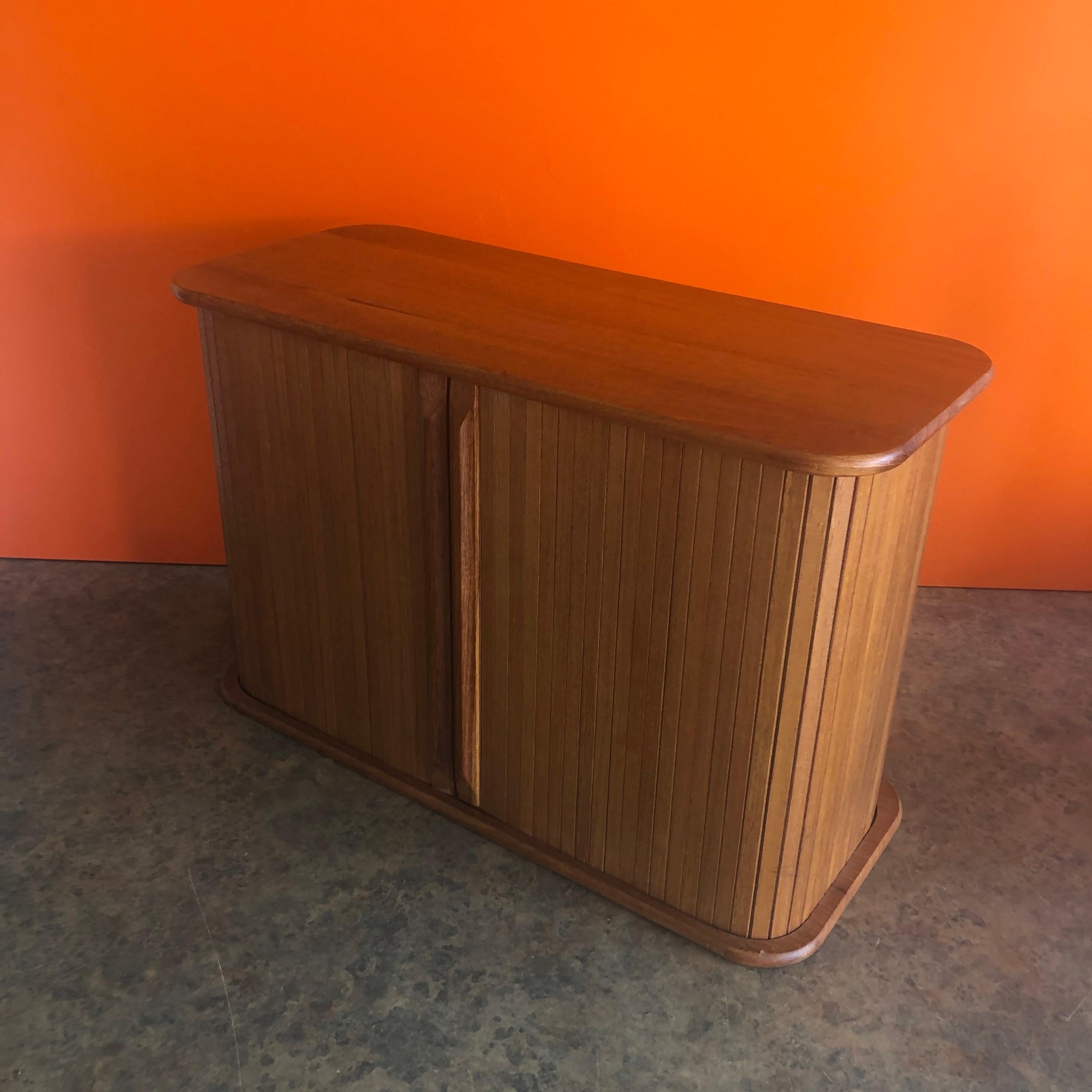 Danish modern solid teak tambour door storage box, circa 1970s. This beautiful well crafted desk top box is great for small storage. The piece can work stand alone or be mounted on a wall.
 
