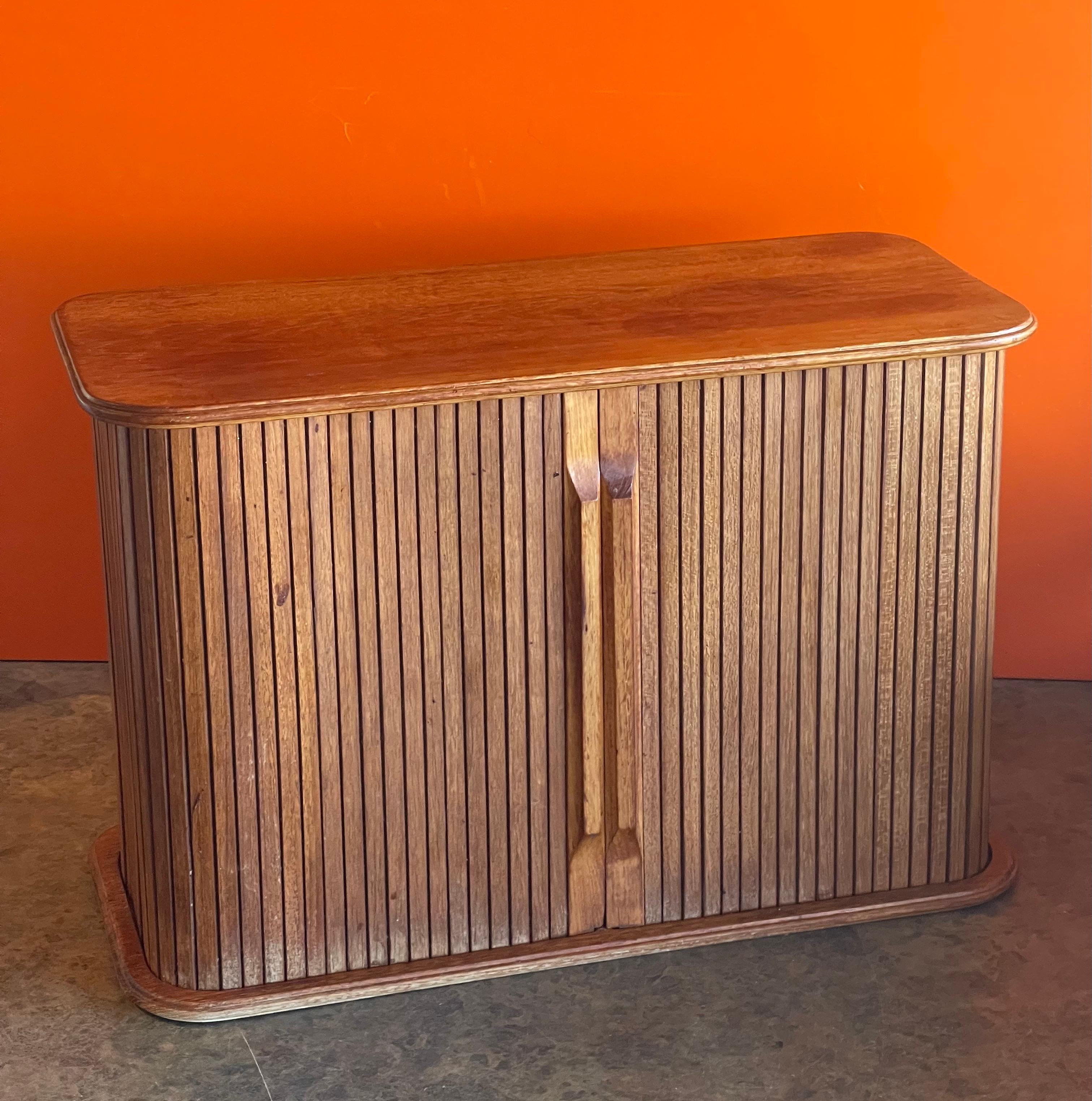 Danish modern solid teak tambour door storage box, circa 1970s. This beautiful well crafted desk top box is great for small storage; the piece can work stand alone or be mounted on a wall. The box is in very good vintage condition and measures 18