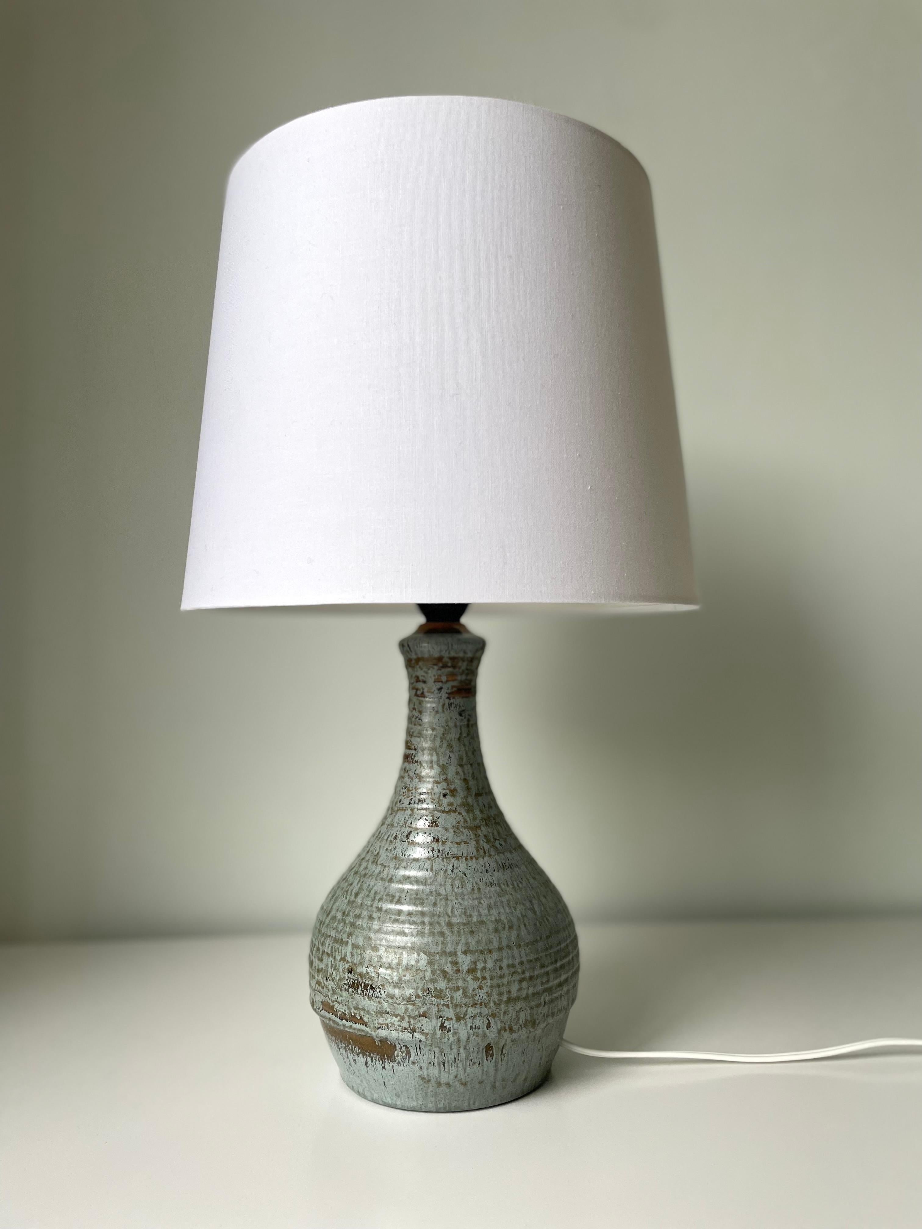 Danish Modern ceramic table lamp with
dusty blue and brown speckled glaze over soft shaped body and slender neck. Handmade by ceramic artist Børge Christoffersen in the 1960s. Signed and stamped under base. Rewired with switch on original fitting