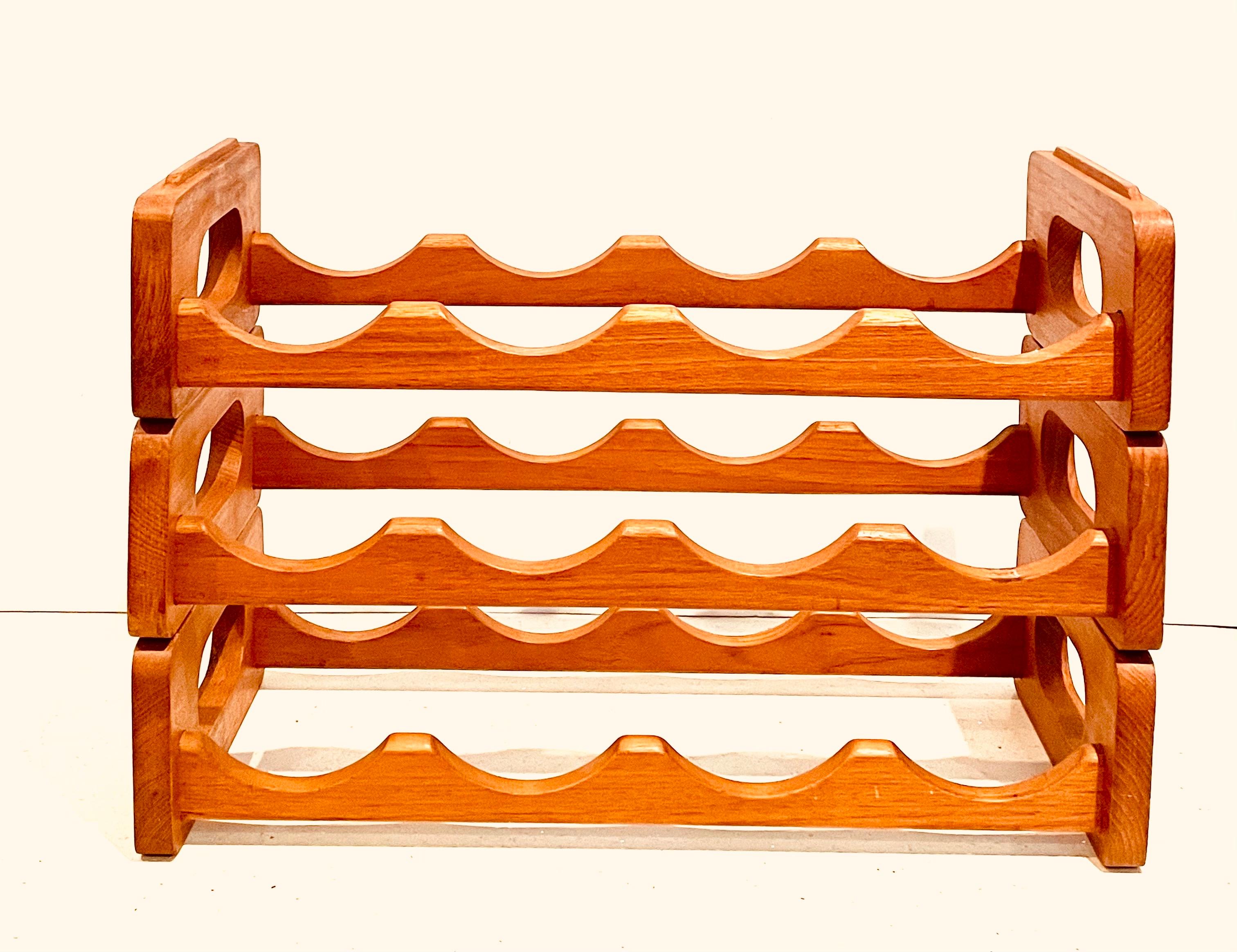 Midcentury stackable solid teak wine rack by Kalmar Designs, circa 1970s. This 3 piece rack can hold up to 12 bottles and is in very good vintage condition. #1085.