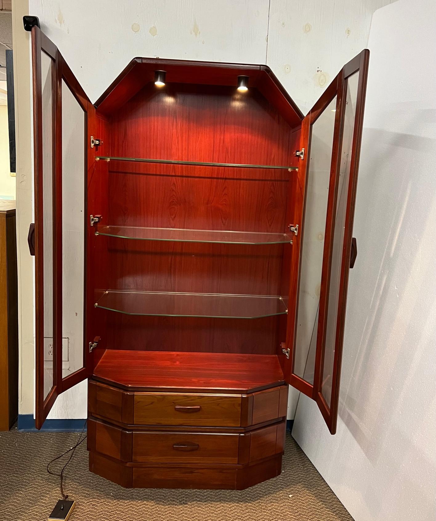 Outstanding Danish rosewood glass display cabinet. Made in Denmark. Three adjustable glass shelves. Bow Front Design. A small light at the top that gives off a cozy glow.
Excellent condition. Minor marks here and there. The plug needs