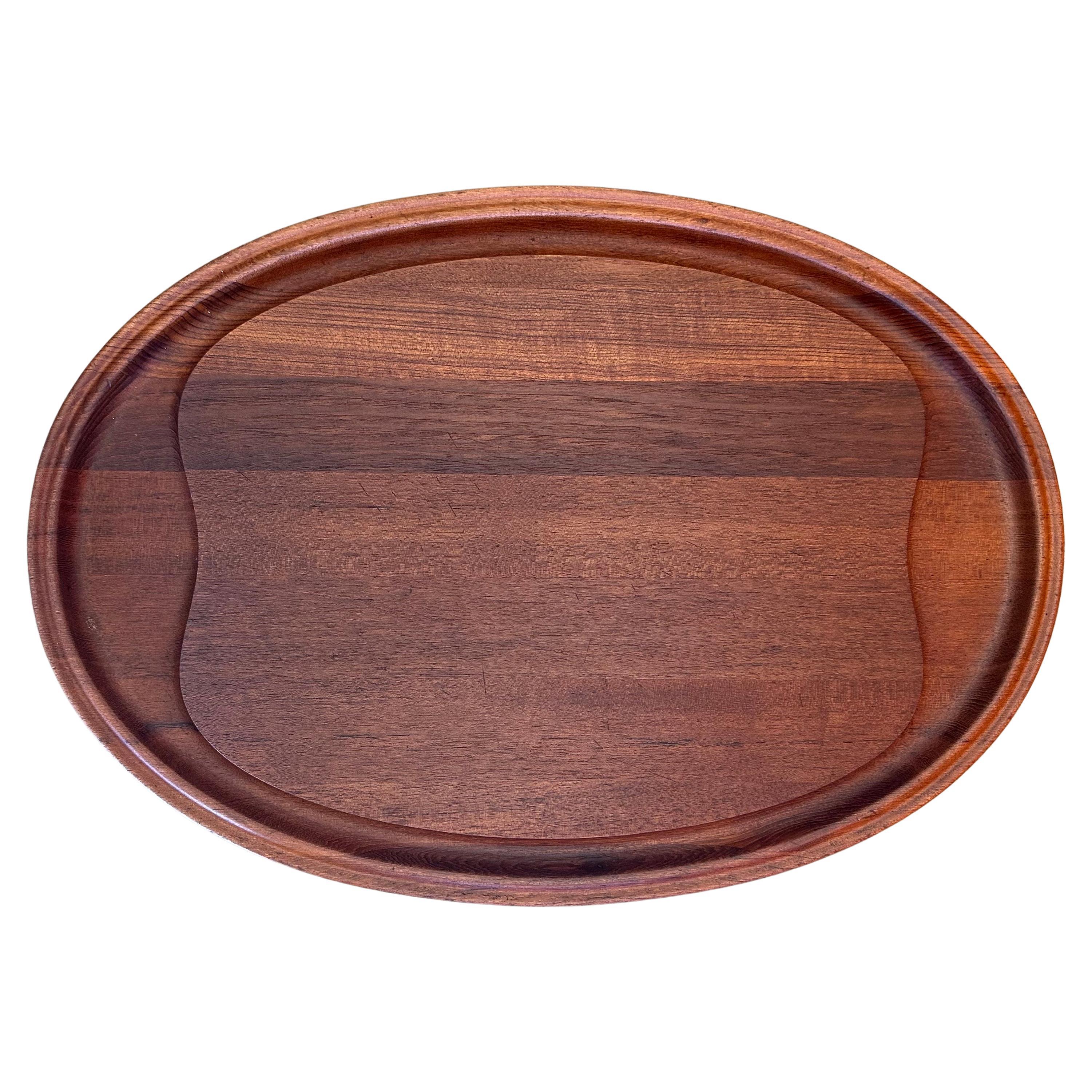 Beautiful Danish modern staved teak carving board by Henning Koppel for George Jensen, circa 1950s. The board is in excellent vintage condition and has been professionally refinished and oiled; it measures 23