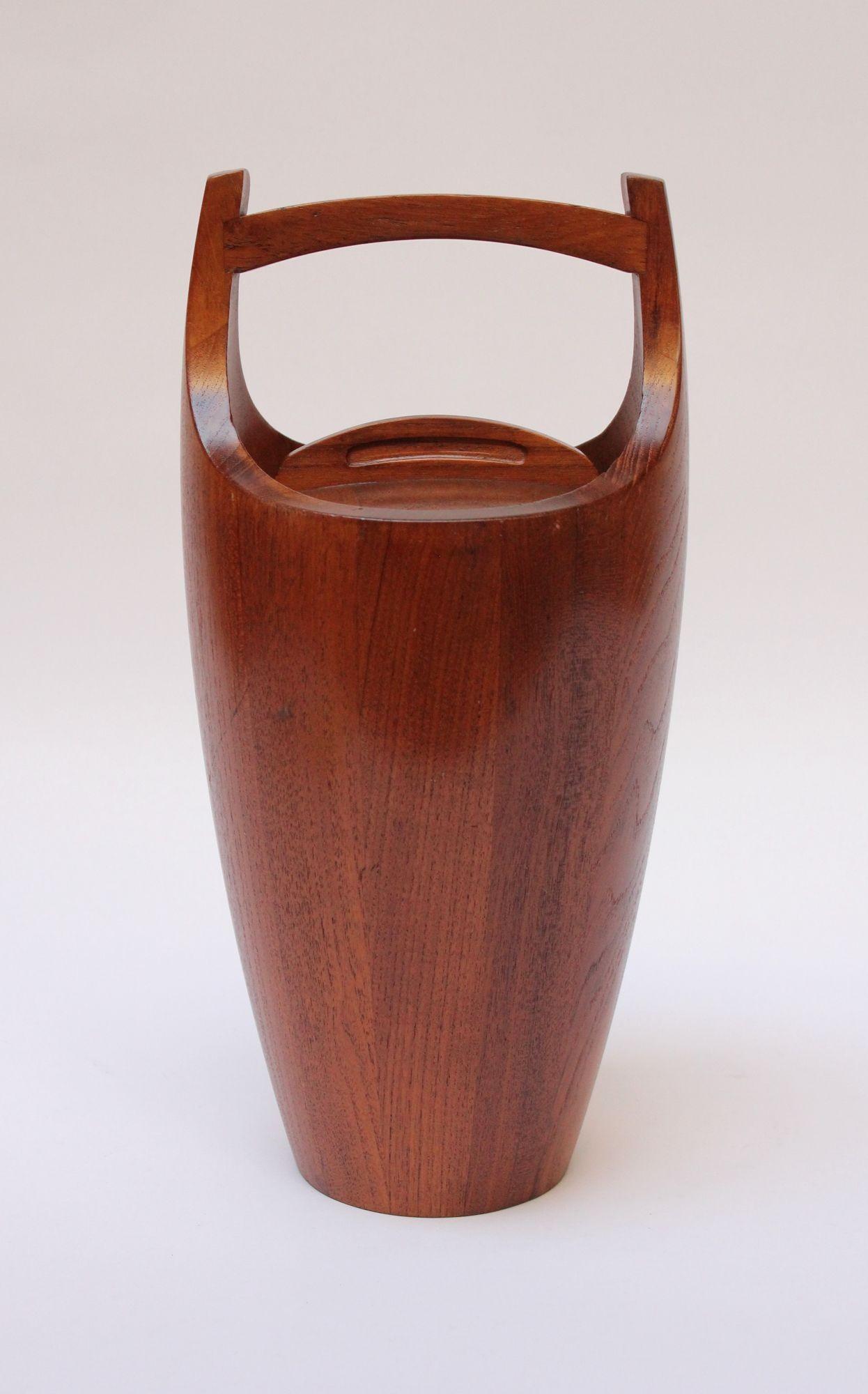 Dansk 'Congo' ice bucket in staved teak designed by Jens Quistgaard for Dansk. Iconic, sculptural early example with signature orange plastic interior liner. 
One scratch present along with a couple of impressions to the exterior and light veneer