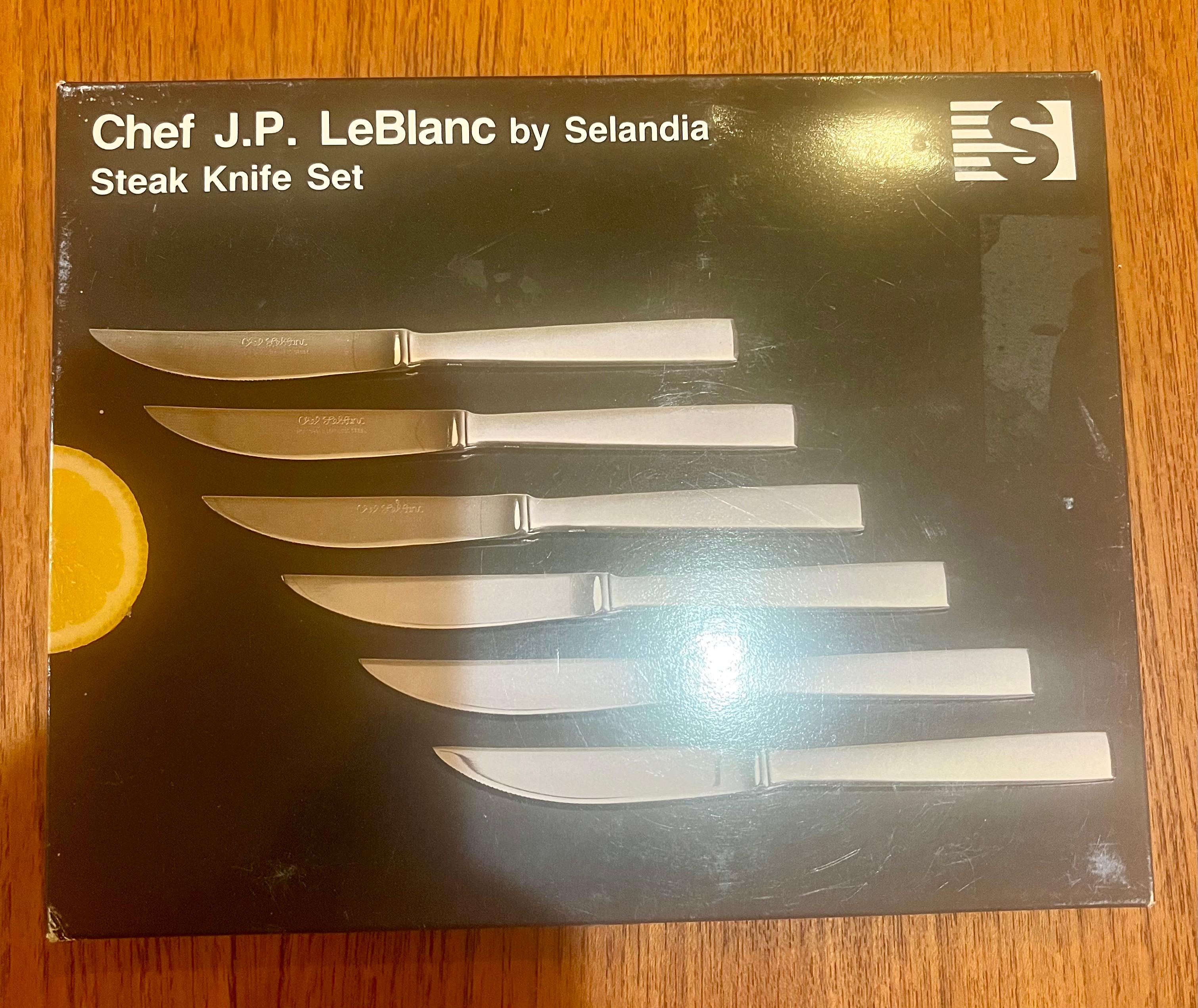 A set of 6 teak and stainless steak knives, designed in the 1970s by Chef JP LeBlanc for Selandia. They were never used. Comes with the box and original plastic sleeves. Beautiful Scandinavian Design.
