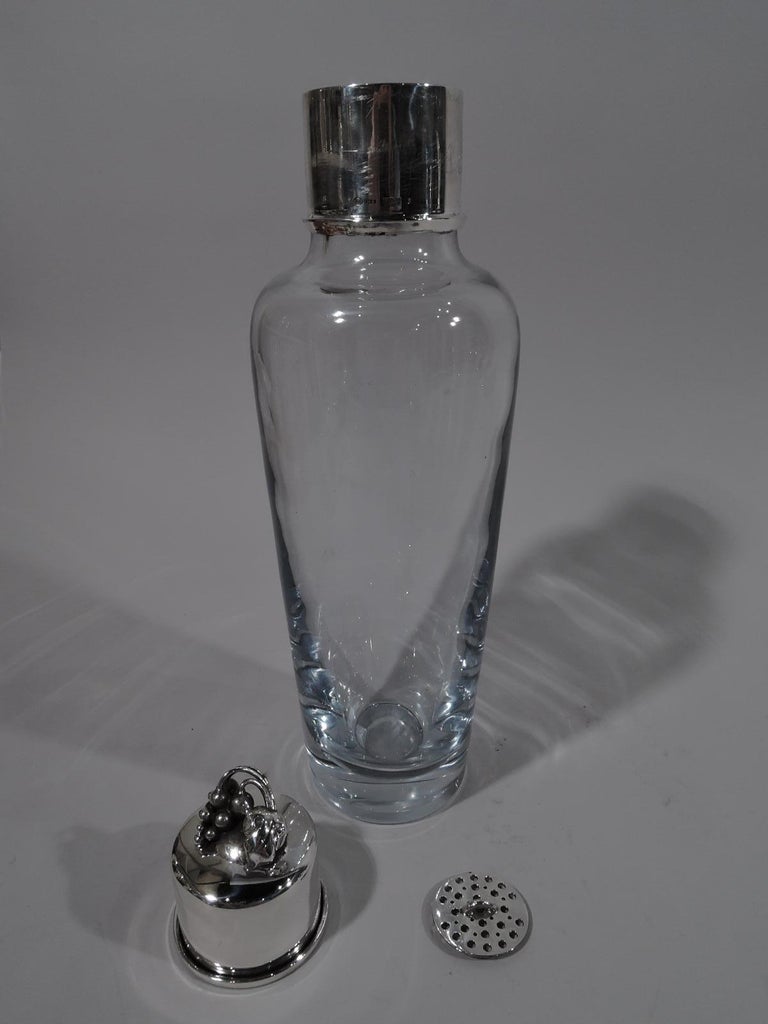 Danish modern sterling silver and glass cocktail Shaker. Tapering clear glass bowl with curved shoulder. Neck in sterling silver collar with detachable strainer. Cover sterling silver with grave bunch finial. Fully marked including maker’s stamp for