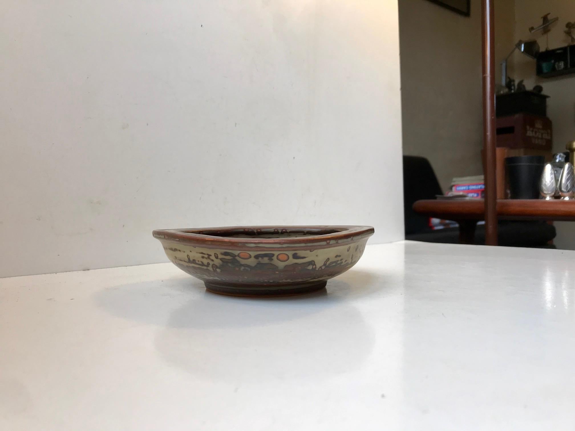 Organically shaped stoneware bowl in earthy sung and crystalline glazes. It was designed by Danish ceramist Bode Willumsen and manufactured by Royal Copenhagen in the late 1940s or early 1950s. Design number 20162.
Early on in his career Bode