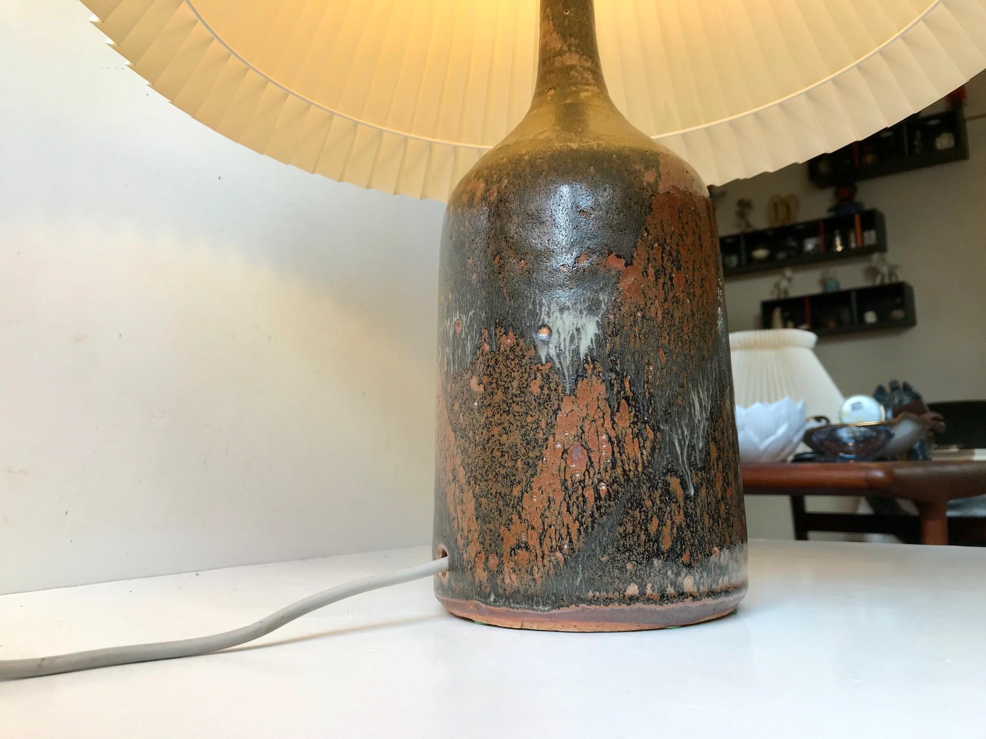 Monumental stoneware table lights with earthy iron-like polychrome glazes. Designed by Danish ceramist Conny Walther during the early 1970s. Its probably from the ceramist own collection hence the rather indistinguishable markings. A remarkable