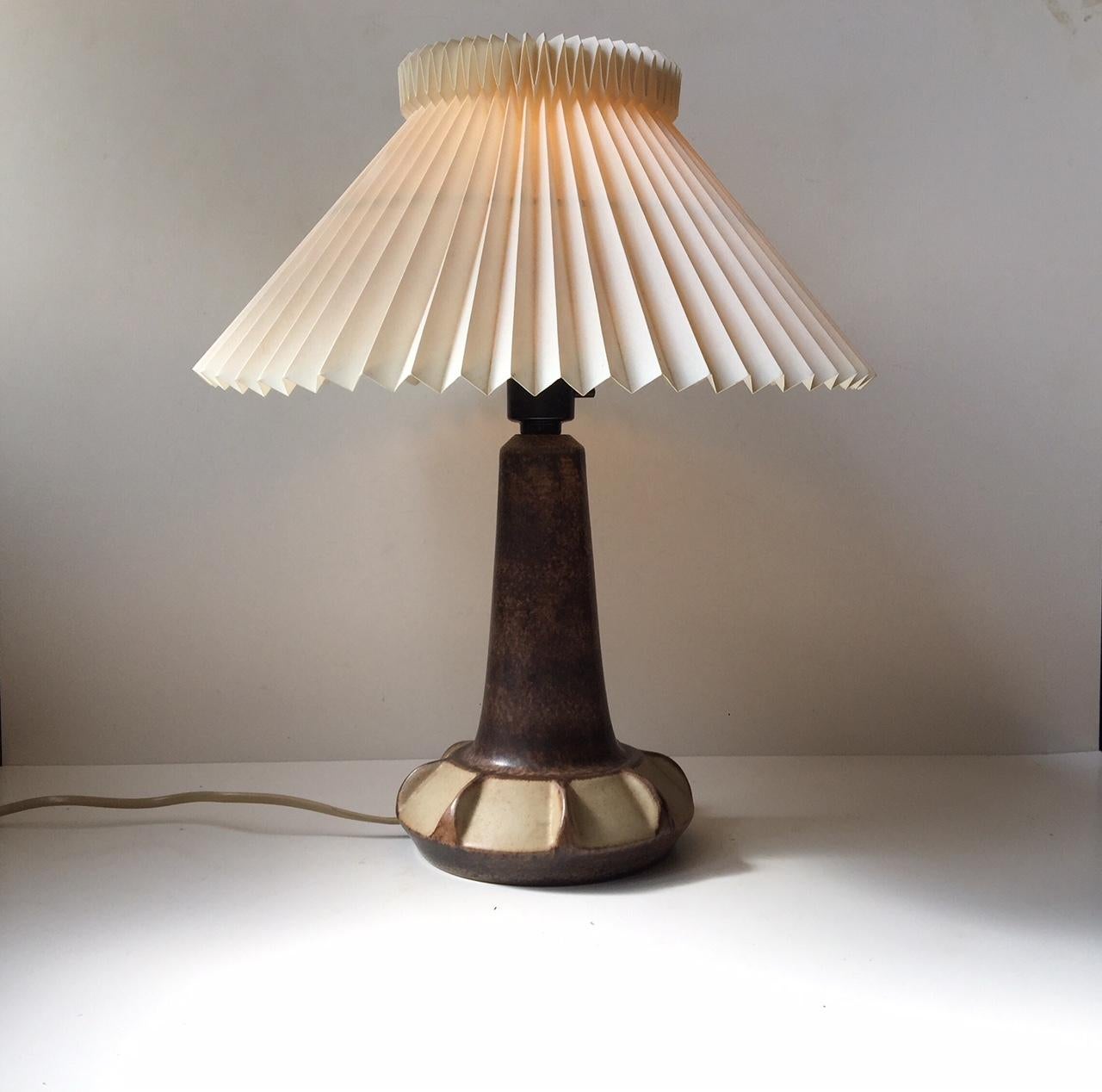 This ceramic table lamp is in earthy brown and pastel glazes. This design was executed at Michael Andersen & Son in Denmark during the 1970s. The light features a pin-switch directly to the socket. The base is marked with both the marker's mark and