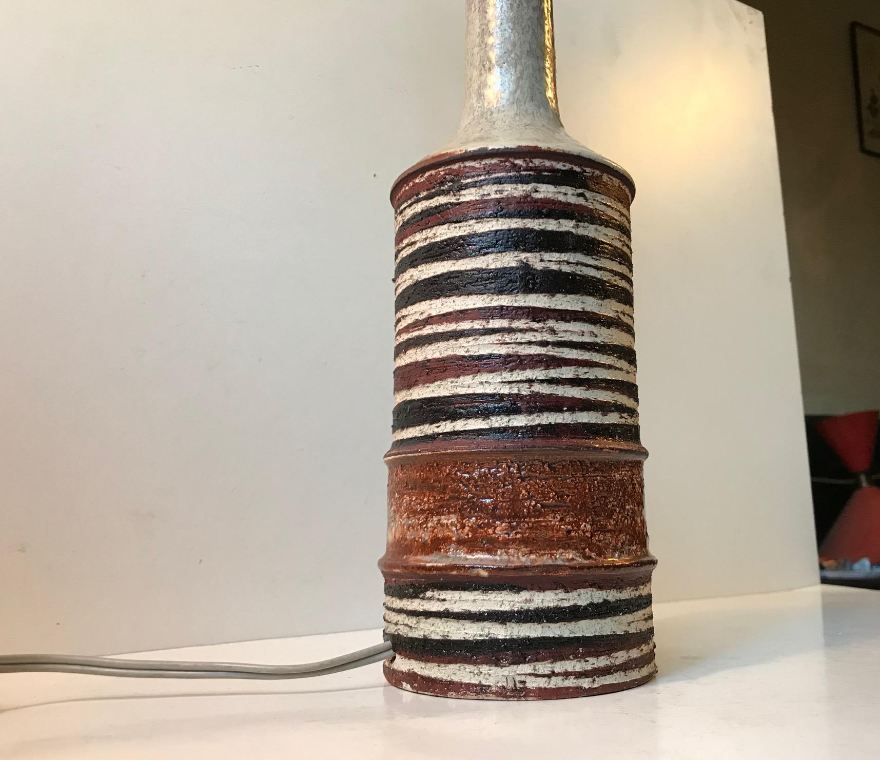 - Stoneware table light decorated with earthy glazes in a striped Tribal motif
- Designed by Jette Hellerøe and manufactured by Axella and Nordisk Solar
- Made in Denmark during the 1970s
- Inscribed by the maker and designer to the base
- Sold