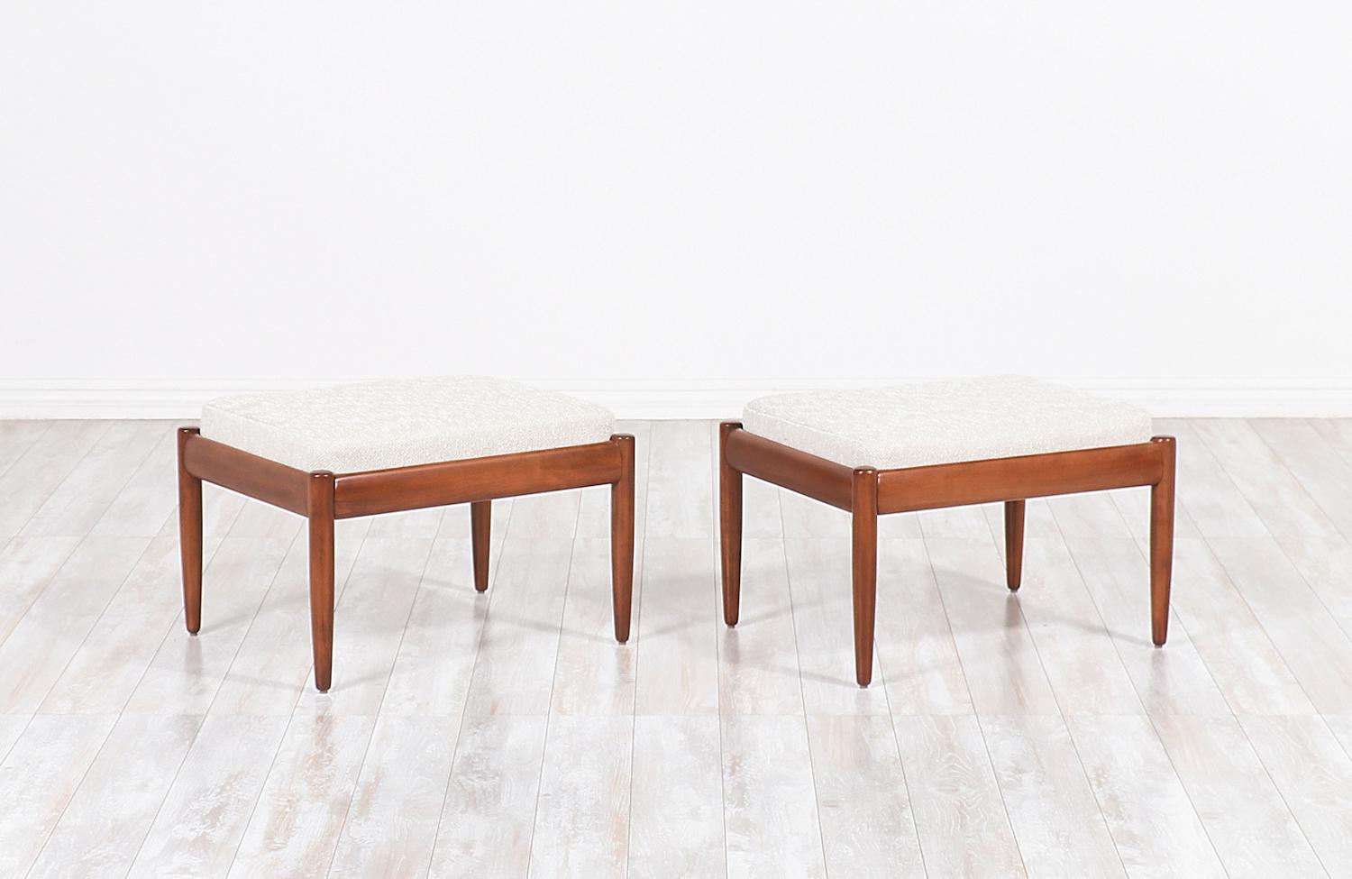 Pair of Mid-Century Modern stools designed by Peter Hvidt for France & Søn in Denmark, circa 1960s. This gorgeous and exceptionally crafted design features a sculpted solid walnut wood frame with sleek tapered legs and new strong springs that
