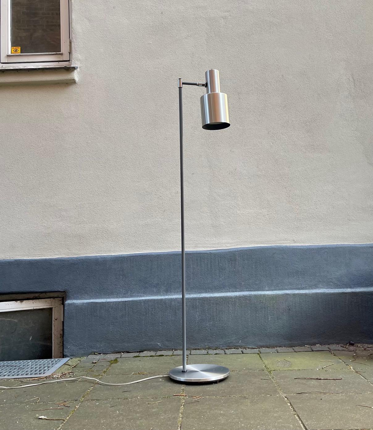 A stylish Scandinavian floor lamp with hidden cord and adjustable shade in brushed aluminum. Designed by Jo Hammerborg in 1963 and manufactured by Fog and Mørup in Denmark during the early 1970s. Measurements: H: 147 cm.

For the US. It will come