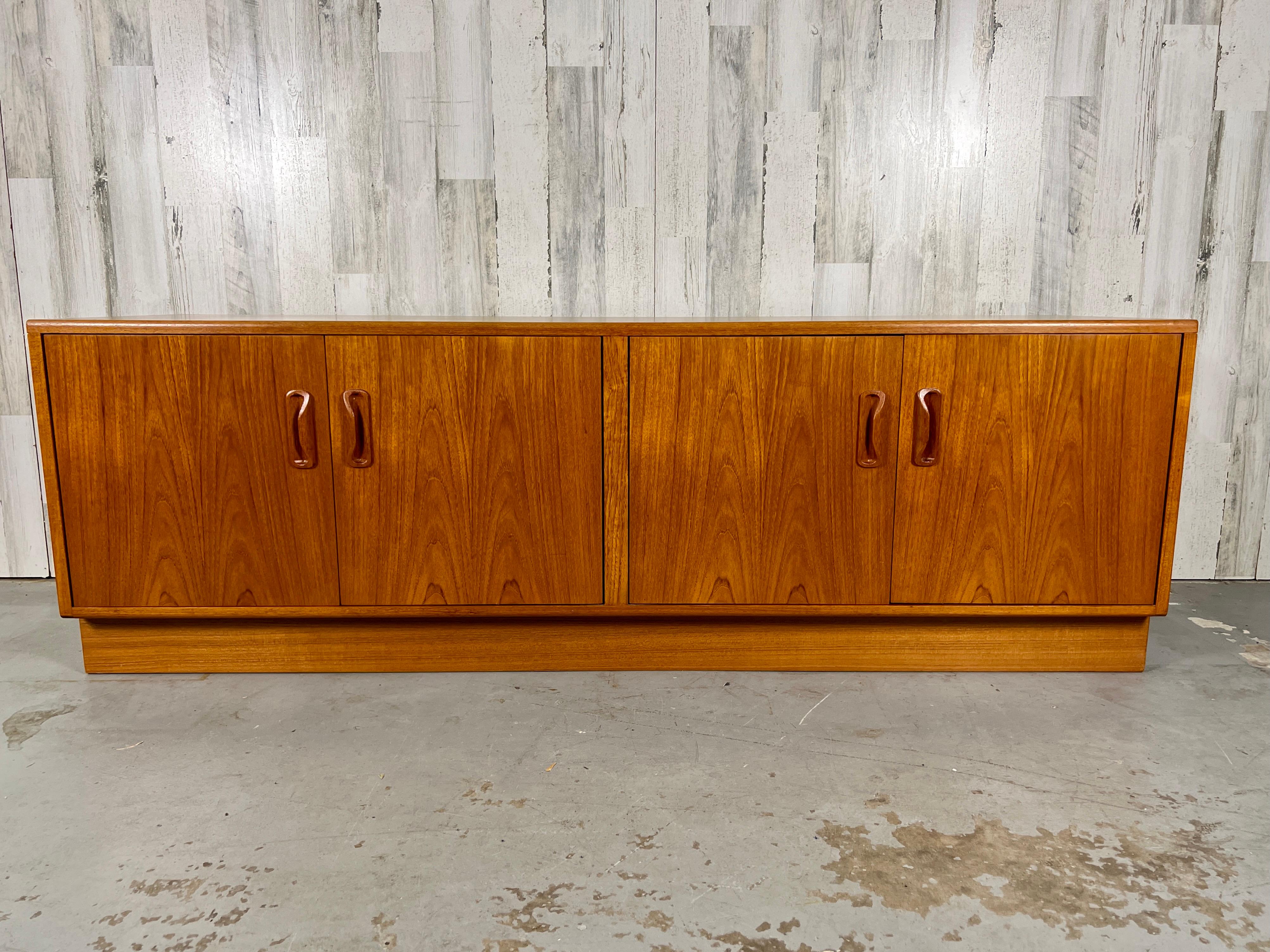 Made by G Plan in England low four door teak credenza with one shelf on each side.