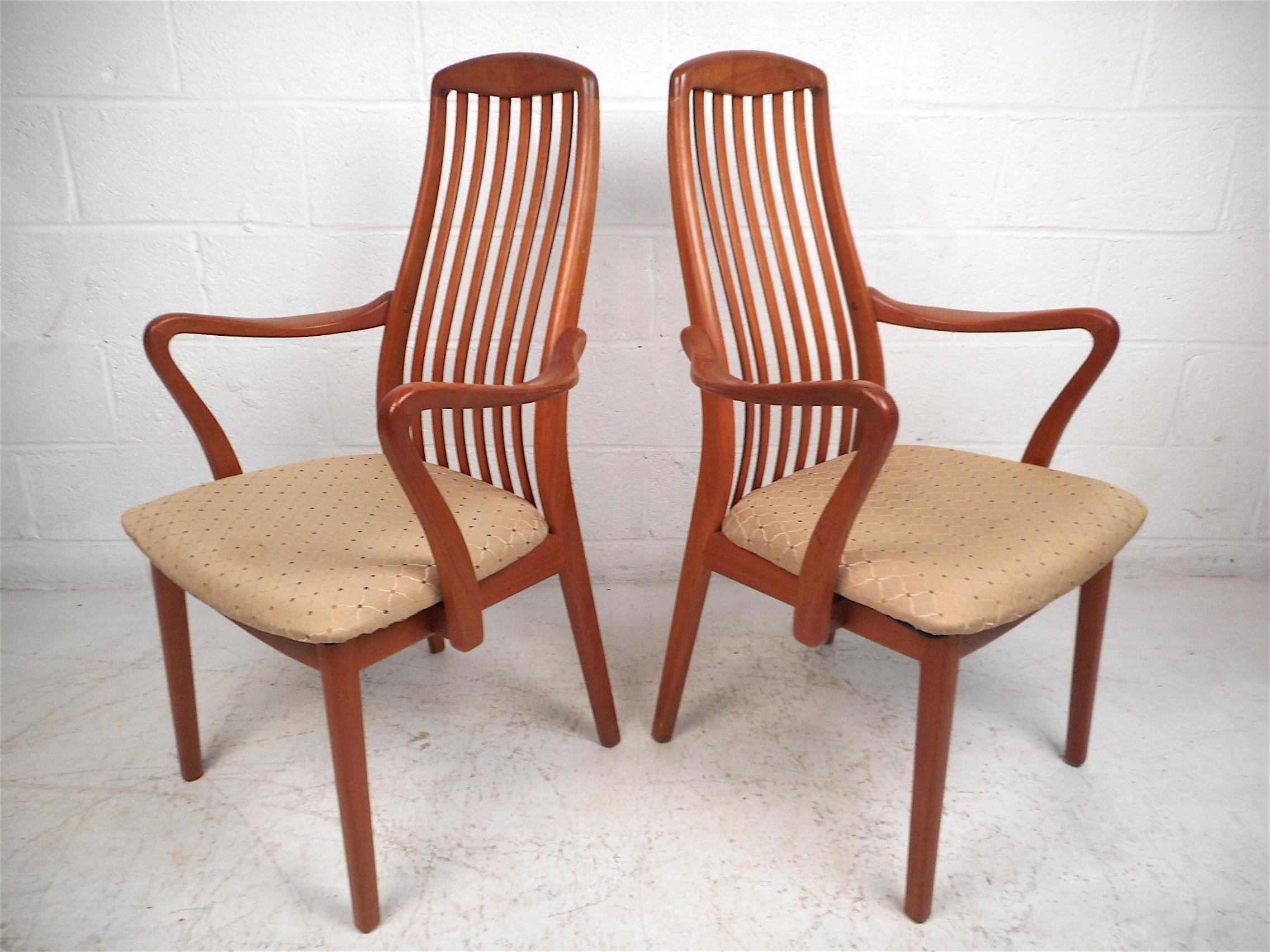 Stylish set of 6 Danish modern style dining chairs. Two of the six chairs have interestingly sculpted armrests. Contoured backrests with vertical stretchers give these chairs a great look. Sure to make a great addition to any modern interior's