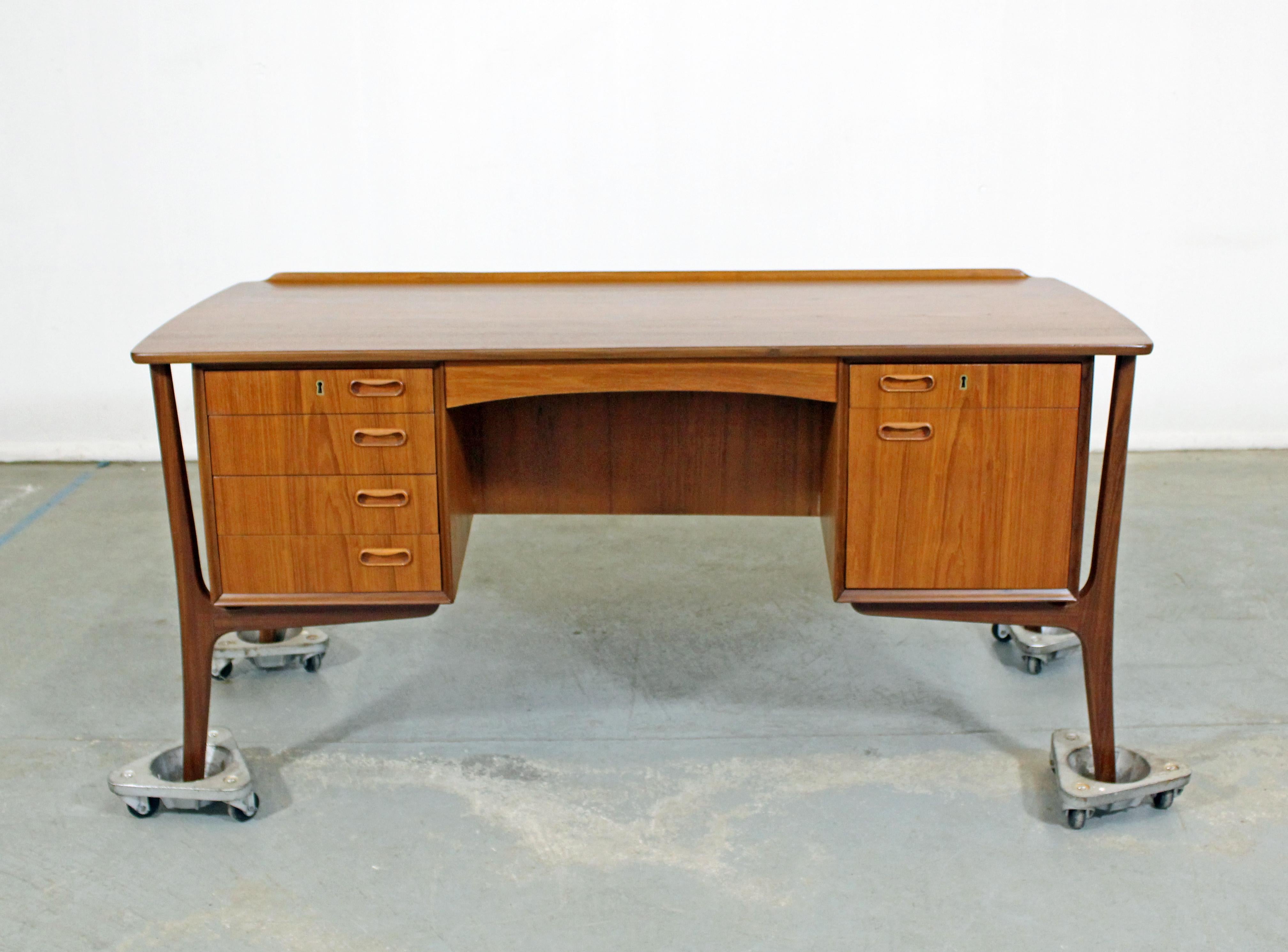 Offered is a completely restored Danish modern desk by Sven Aage Madsen. Has been professionally refinished. This piece is made of teak with a floating frame and beautifully sculpted legs. Includes 6 drawers, two with locks and including one for