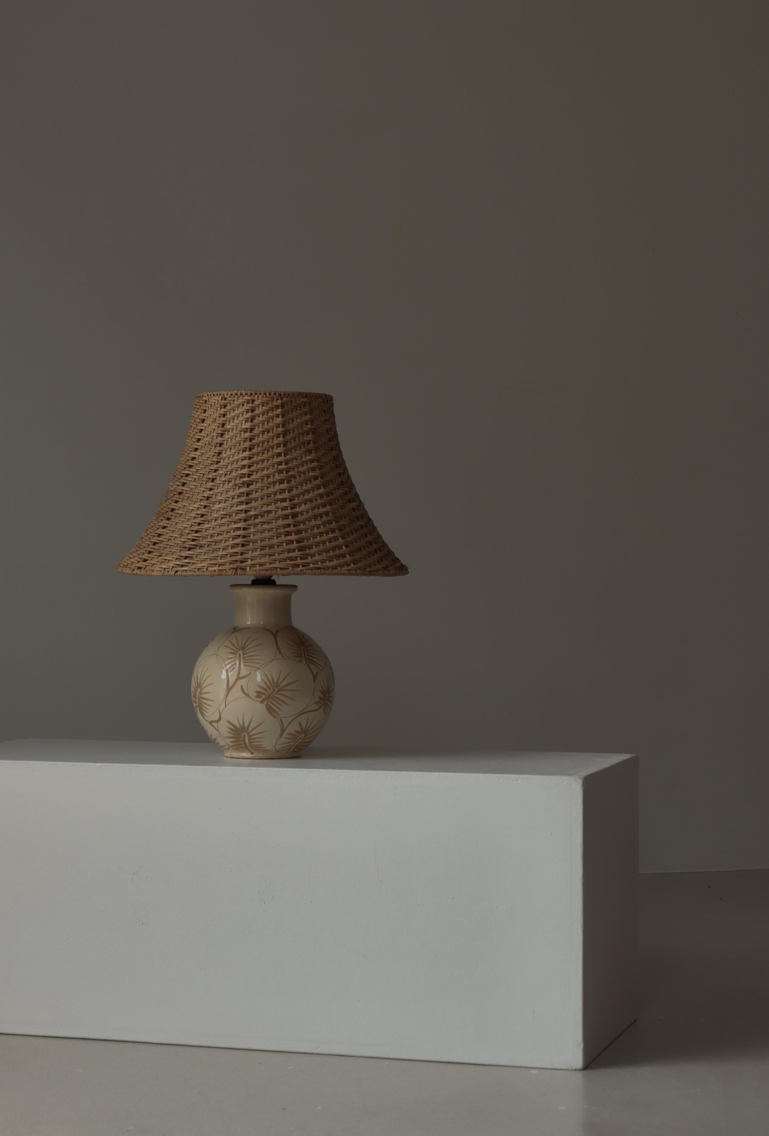 Lampe de table en céramique magnifiquement fabriquée à la main, conçue par Astrid Tjalk pour Kähler Keramik, Danemark, années 1950. La base arrondie et globulaire est ornée du motif botanique incisé à la main, signature de Tjalk, un motif rythmique