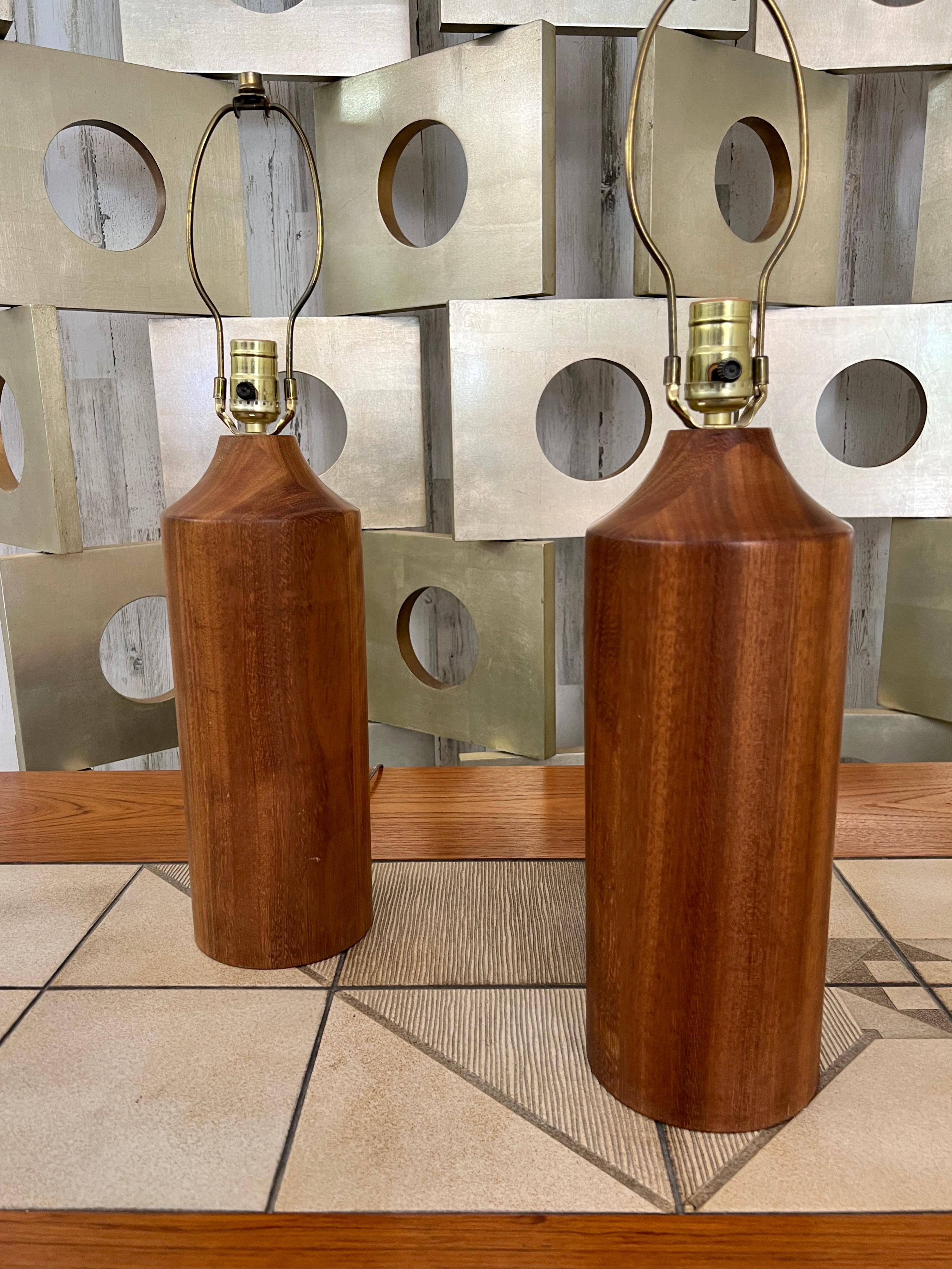 Solid teak cylinders with tapered top.
