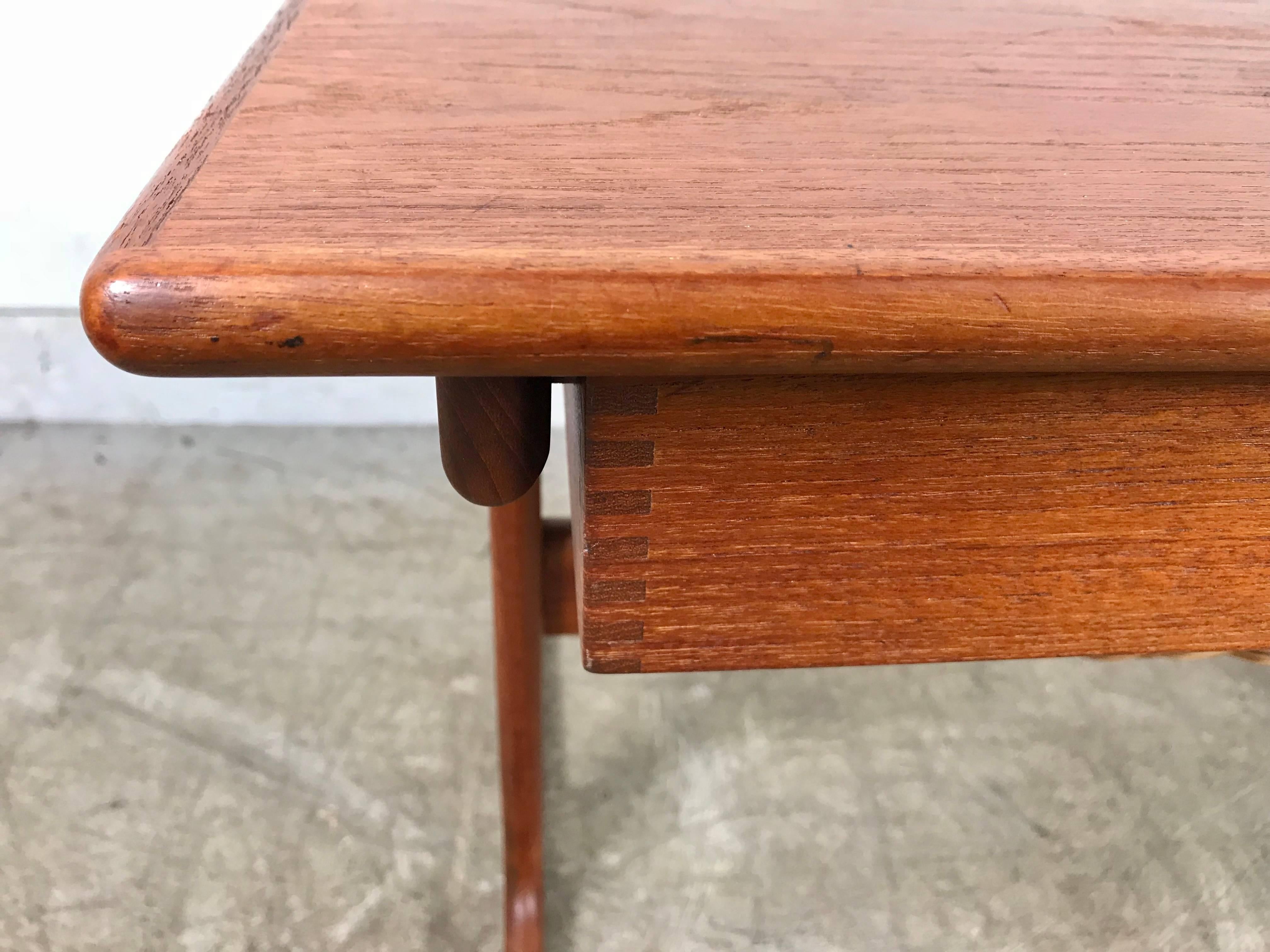 This teak sewing table was designed by Severin Hansen Jr. for Haslev Mobelsnedkeri in the 1960s and is comprised of a woven rattan basket below a shallow, hidden finger joint drawer, fitted for sewing implements, although the piece was designed to