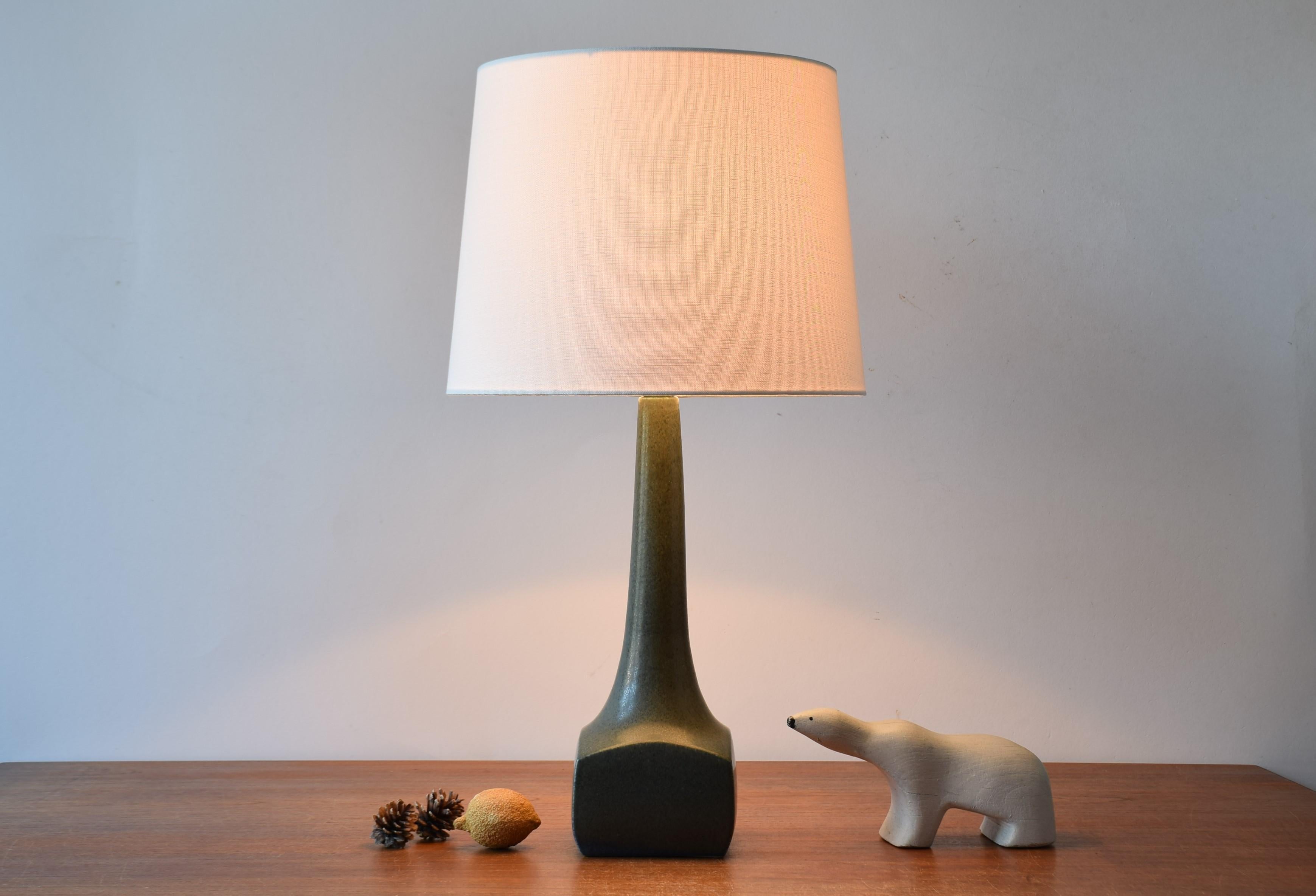 Midcentury Danish table lamp from the ceramic workshop of Michael Andersen & Søn (Michael Andersen & Son) on the Danish island Bornholm. Designed and made ca 1960s.
The lampbase is made of stoneware has a matte bottle green slightly speckled glaze