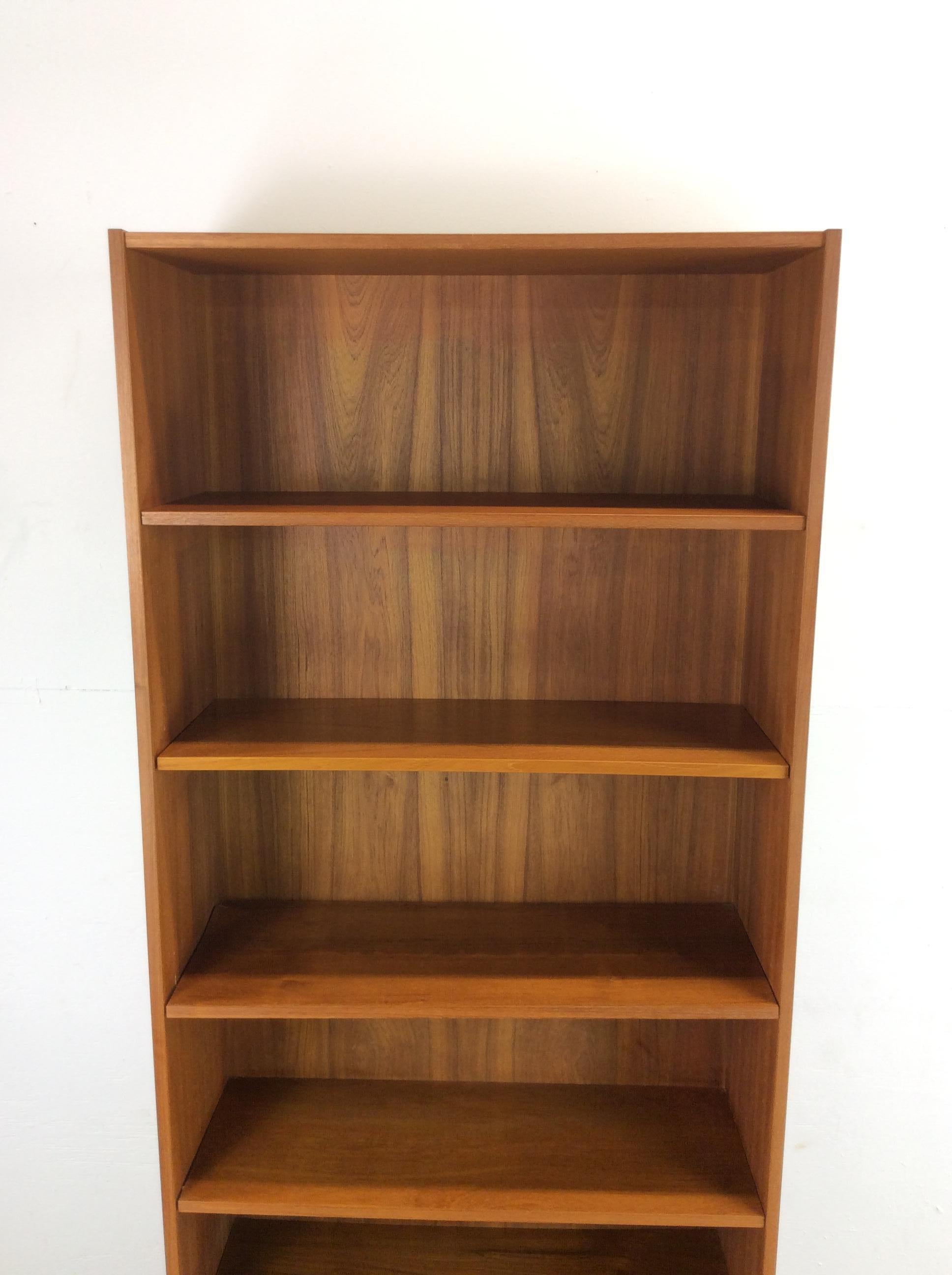 This Danish Modern bookcase features pressed wood construction, beautiful teak veneer with original finish, and five adjustable shelves.

Matching bookcase and other complimentary Danish items available separately.

Dimensions: 31.5w 11.5d 72.25h