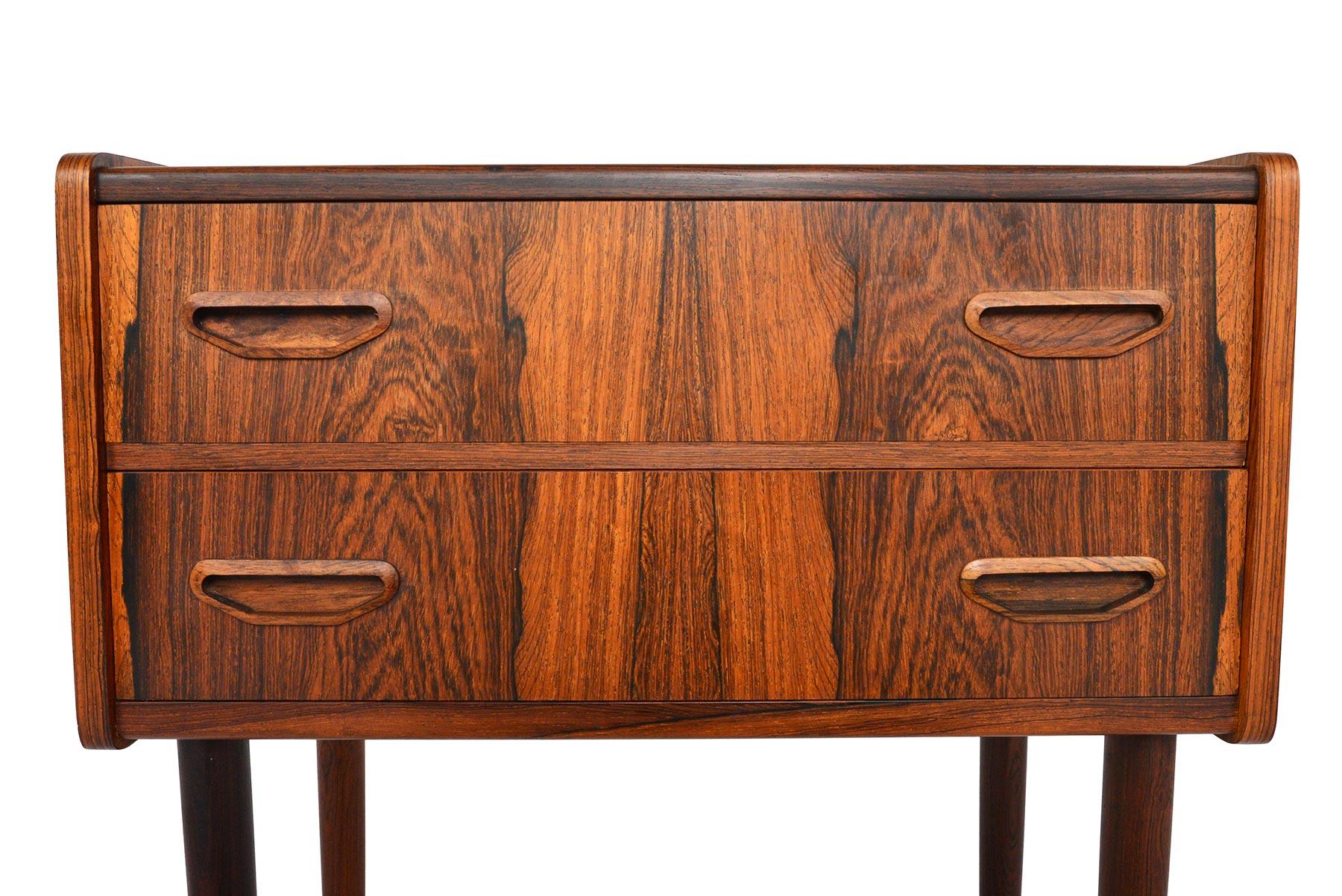 This Danish modern entry chest in rosewood is absolute perfection. A tall narrow profile houses two drawers with carved pulls. Breathtaking book- matched Brazilian rosewood woodgrain covers the case. In excellent original condition with typical wear
