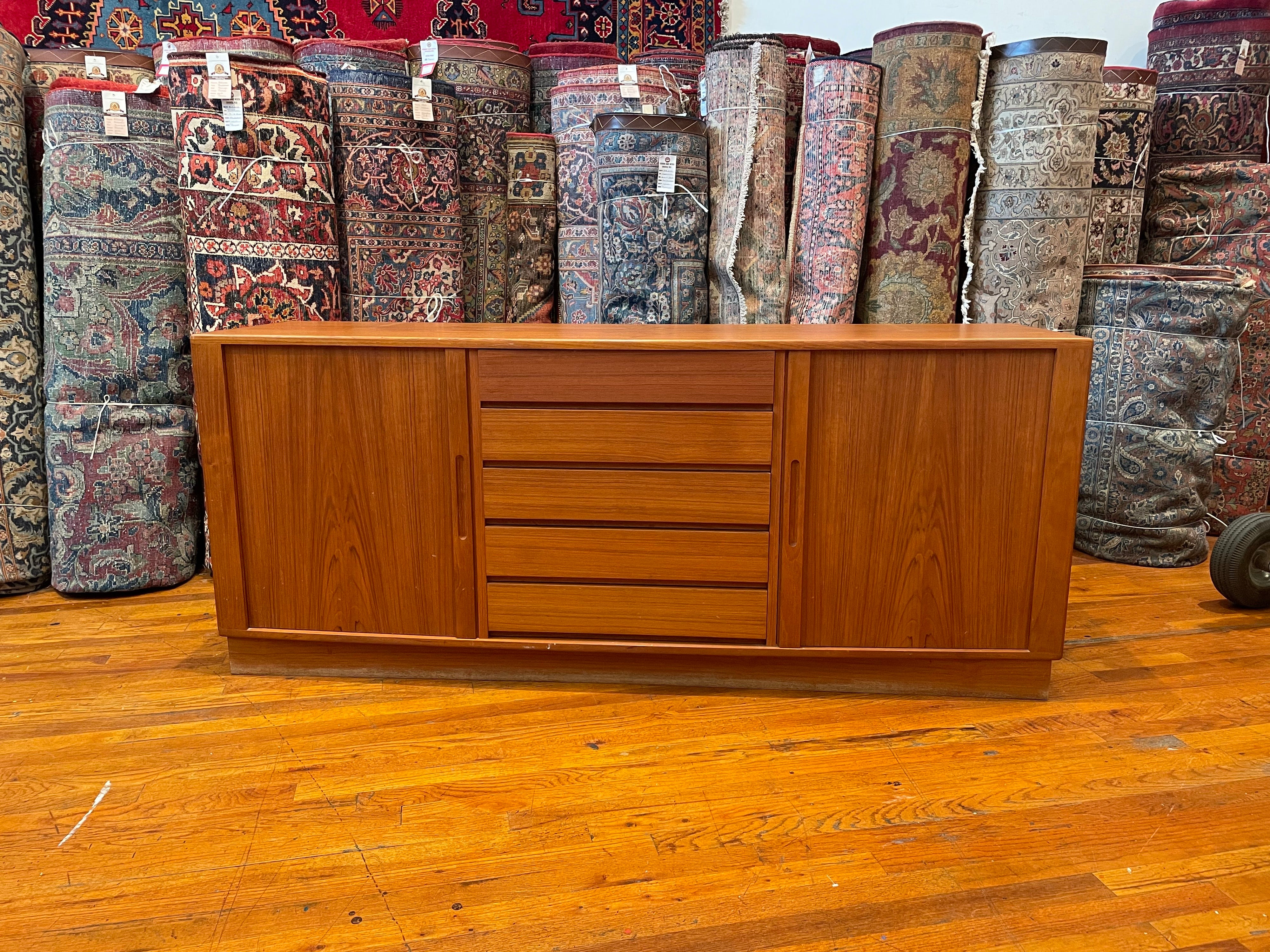 1980's Danish teak credenza in teak with tambour doors. and middle dove tail drawers, original finish we have cleaned and oiled the piece looks great with light wear due to age great quality refinished in the back.