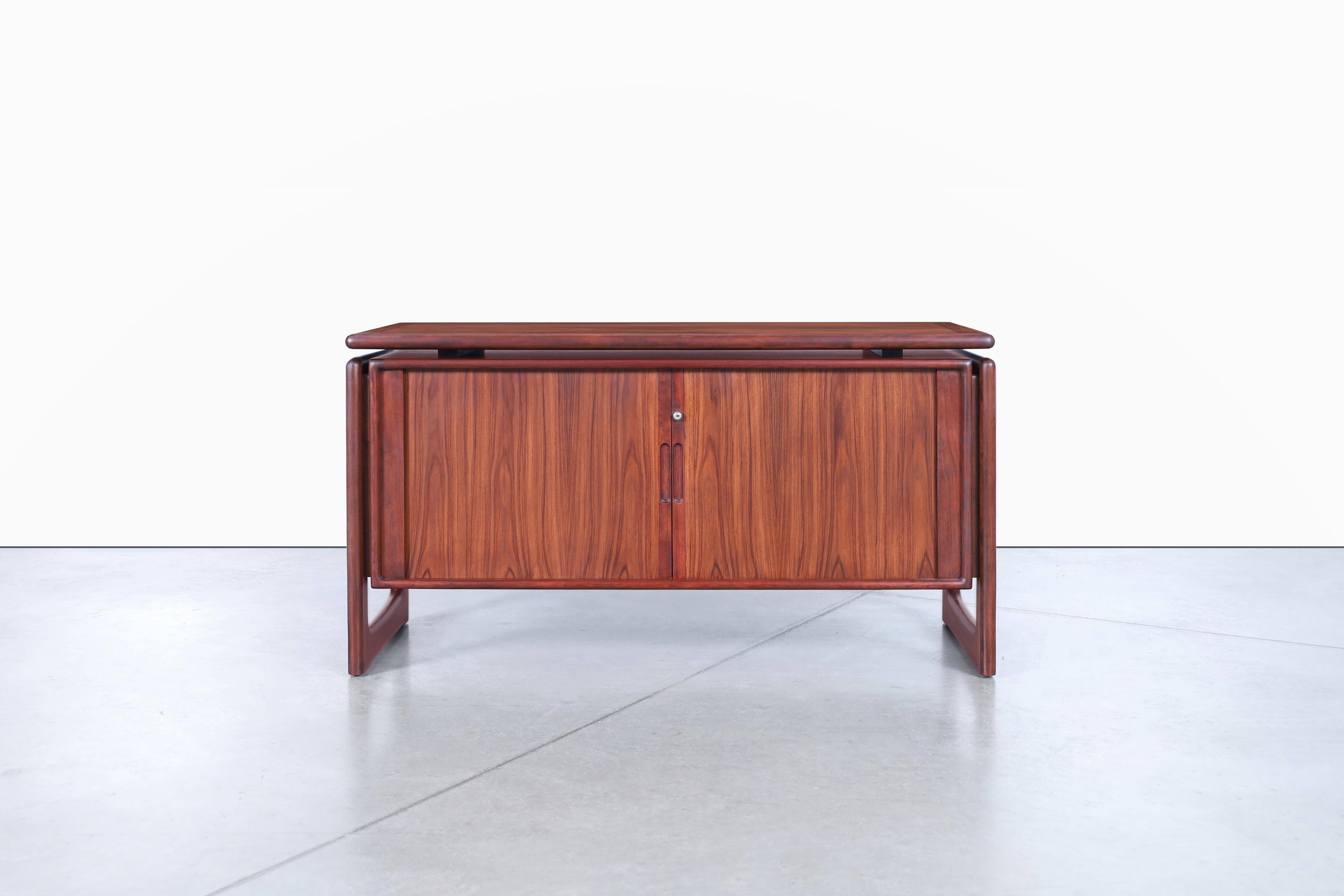 Introducing a stunning Danish modern tambour door credenza by Dyrlund, crafted in Denmark during the 1960s. This remarkable piece features two tambour doors that elegantly wrap around the cabinet, providing a seamless and concealed look when open.