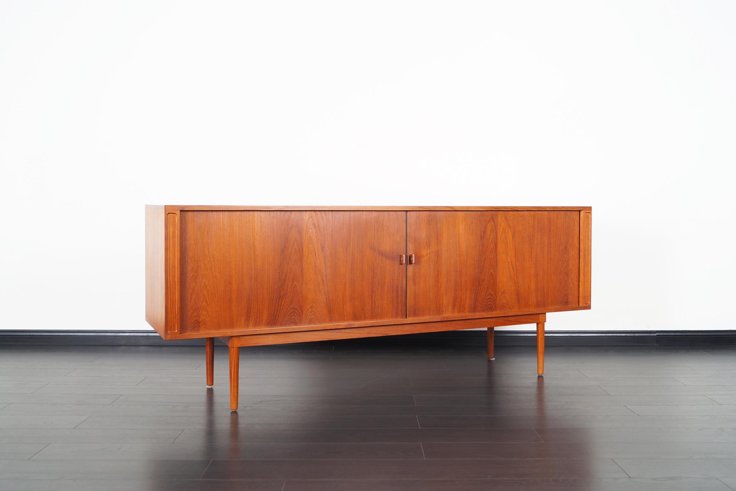 Elegant Danish modern tambour door credenza designed by Peter Løvig Nielsen for Løvig design. Features two sliding tambour doors that smoothly open up to three sections. The middle section has five dovetailed trays. On each side there's one