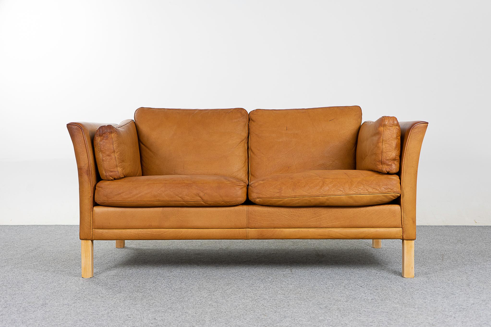 Leather mid-century loveseat, circa 1960's. Original tan leather is soft and supple while also being durable to ensure years of use and enjoyment. Compact footprint make this the perfect seating solution for urban dwellers in cozy lofts or