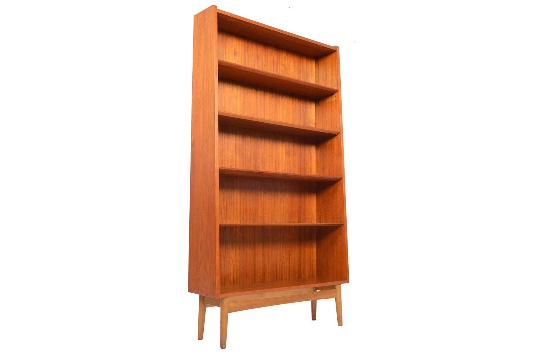 This stately Danish modern midcentury bookcase in teak by Bornholms is the perfect storage piece for any modern home. Four adjustable shelves provide versatility for storage. Case stands on a beautiful oak base. In excellent original condition with