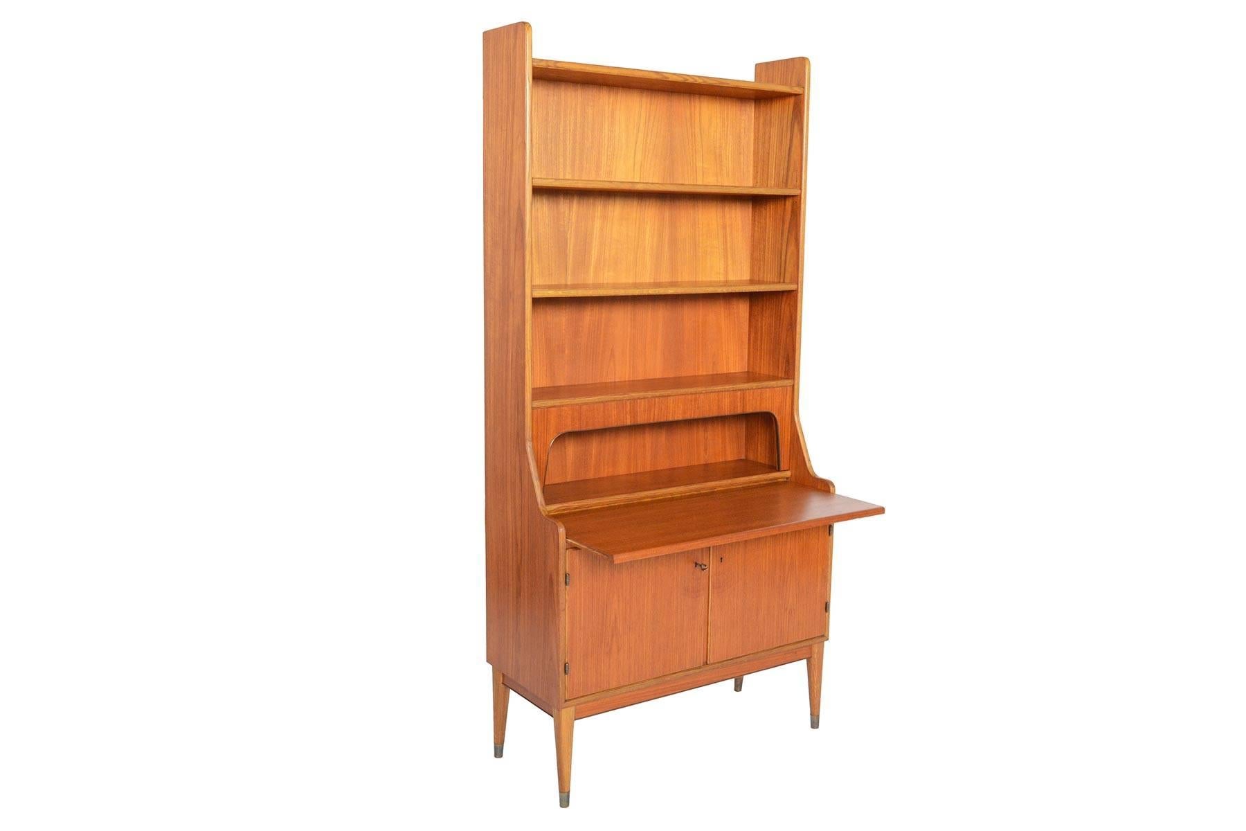 This Danish modern teak and oak bookcase with secretary desk is a wonderfully versatile storage piece! Crafted in teak, this bookcase is accented with oak along the sides and shelves. The bookcase top offers two adjustable shelves. A pull- out desk