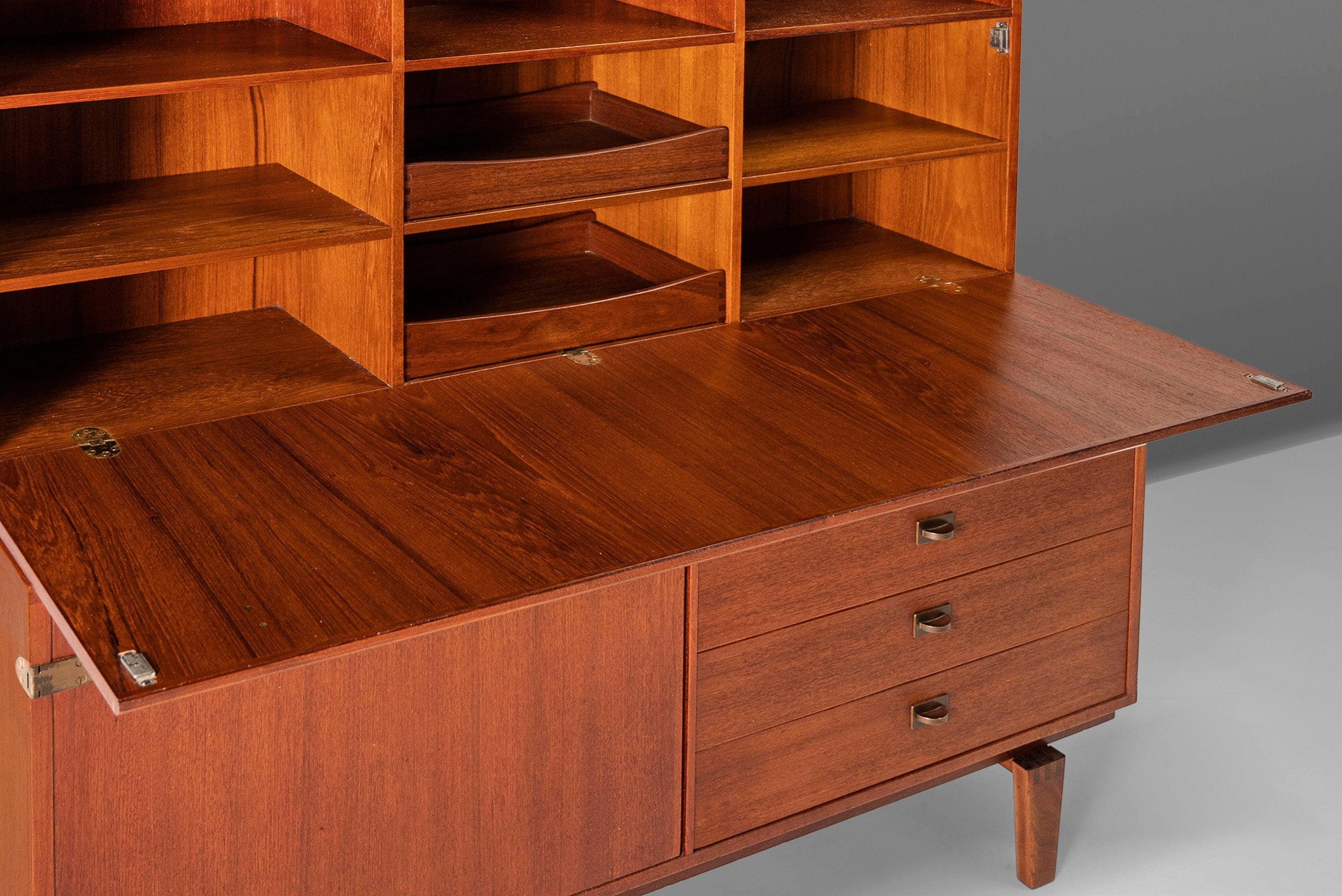 Un design ricercato ed eccezionalmente ben costruito di Peter Lovig Nielsen per Dansk Designs. La vetrina in due parti è realizzata in teak. La parte superiore della libreria è dotata di undici ripiani regolabili che offrono un ampio spazio per