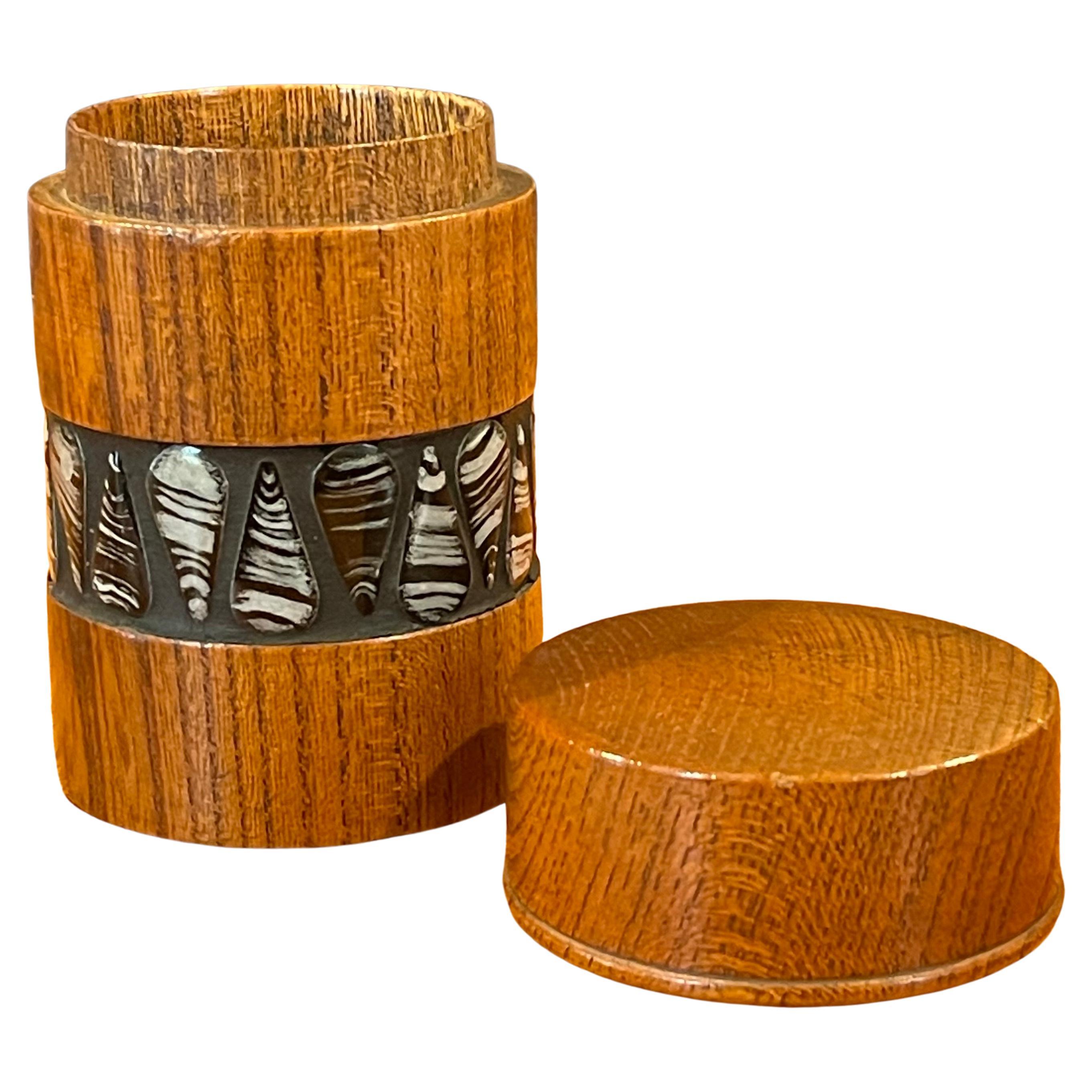 A pristine and absolutely gorgeous teak and ceramic lidded match box / container in the style of Sigvard Nilsson, circa 1950s. The box is made of solid teak wood with a very cool black and white ceramic tear drop band.  The piece is super rare and