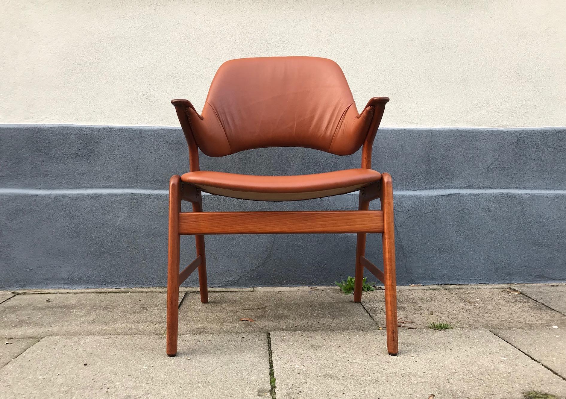 Solid teak armchair or lounge chair recently upholstered in tanned brown aniline leather. The 'nails' armrests are made from hand sanded/finished oak. It was manufactured by N. A. Jørgensen (later Bramin) in Denmark in the early 1960s. It may have