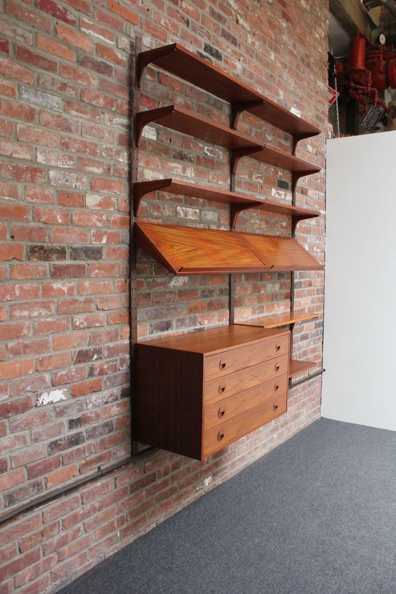 Two-bay modular teak wall unit designed by Rud Thygesen and Johnny Sørensen for Hansen and Guldborg (Denmark, 1960s).
Features the three original rosewood rails/uprights supporting the teak components - one four drawer cabinet with circular, inset
