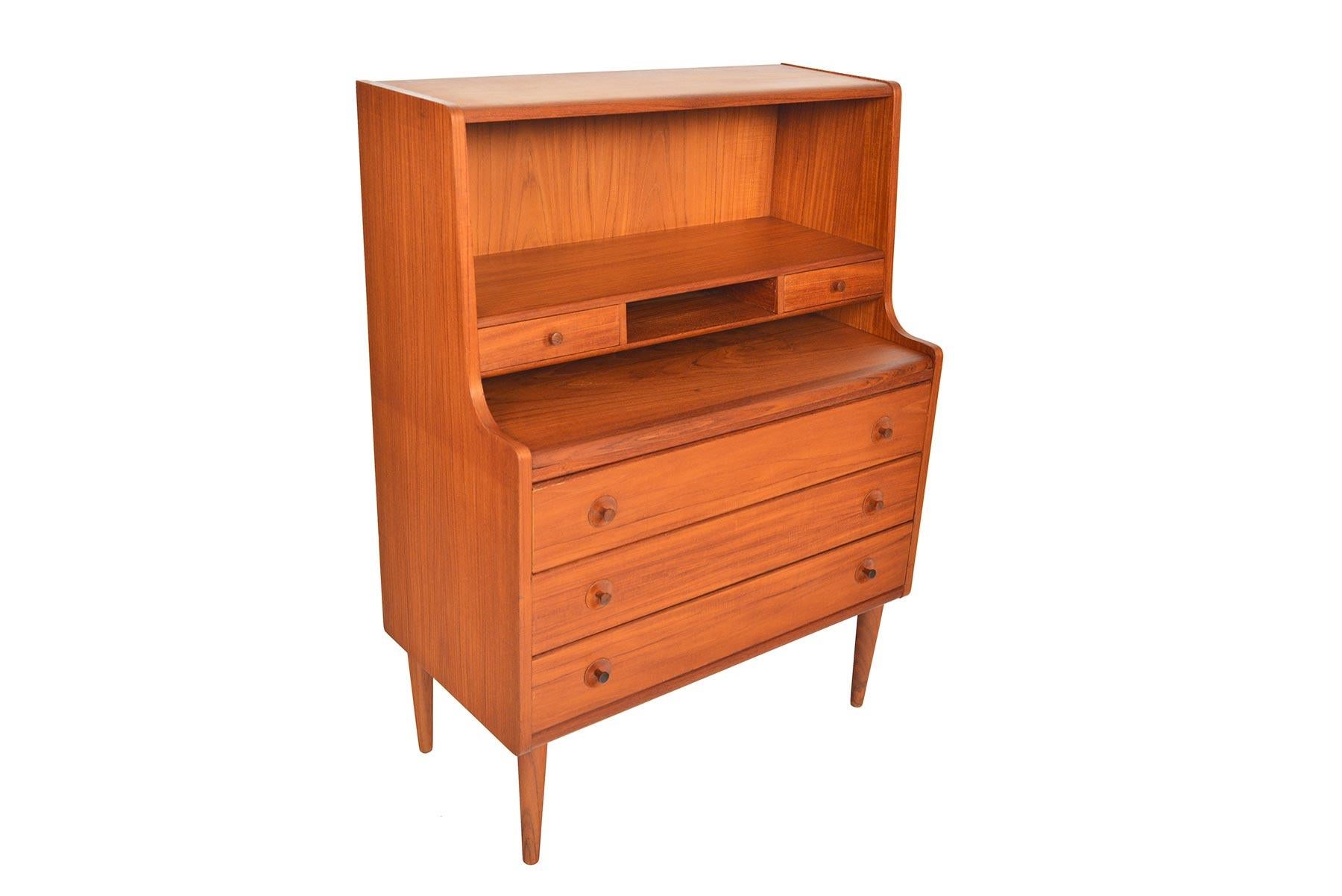 This incredible Danish modern secretary desk in teak hails straight from the 1960s! The center of this piece features a pullout desk and provides a spacious work surface. Two small upper drawers and three large, lower drawers offer the perfect