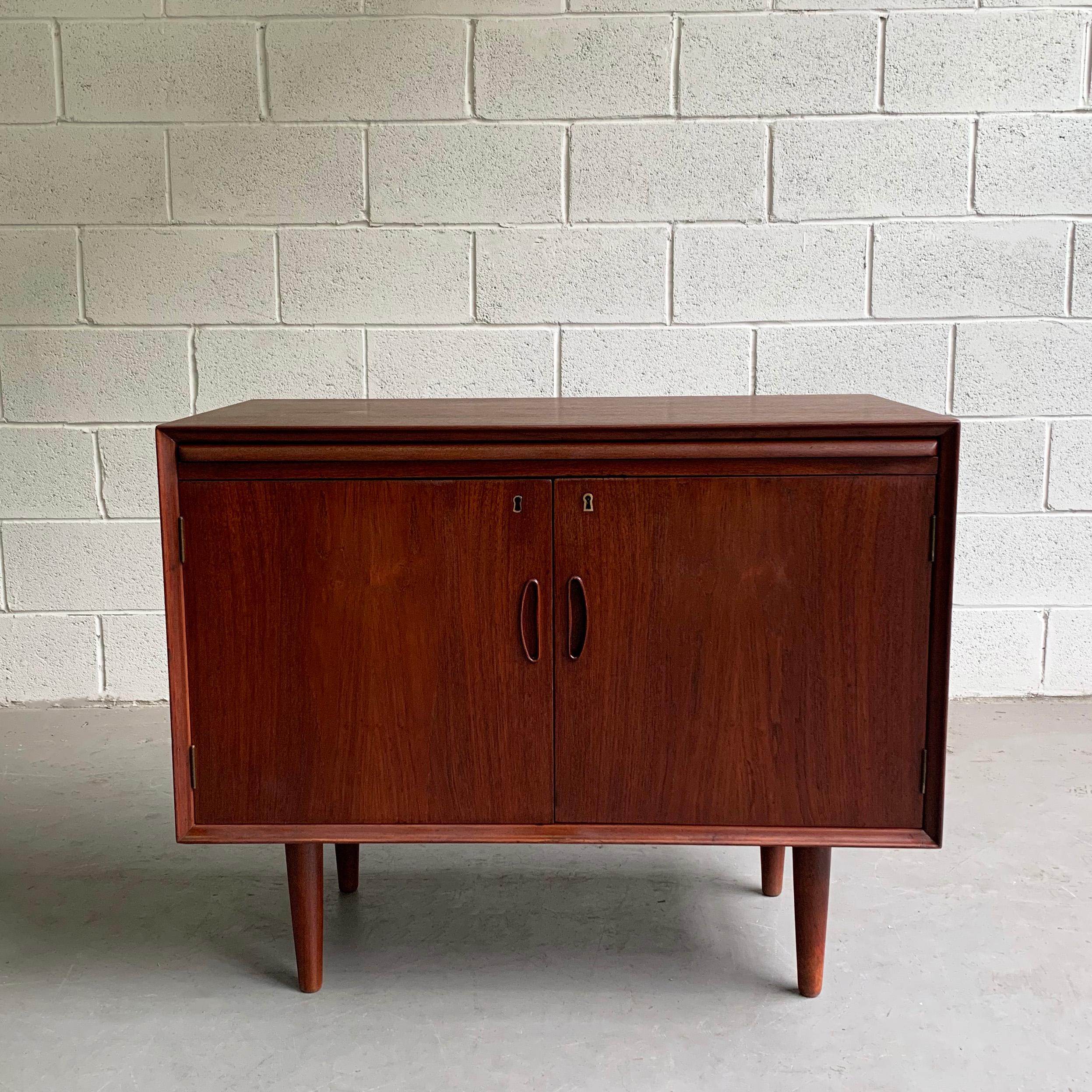 Scandinavian modern, teak bar cabinet or small credenza with recessed eyelet handles features open interior storage with 2 slim drawers on top and a pull-out, vinyl covered ledge for mixing drinks. The cabient is finished on it's back. There is no