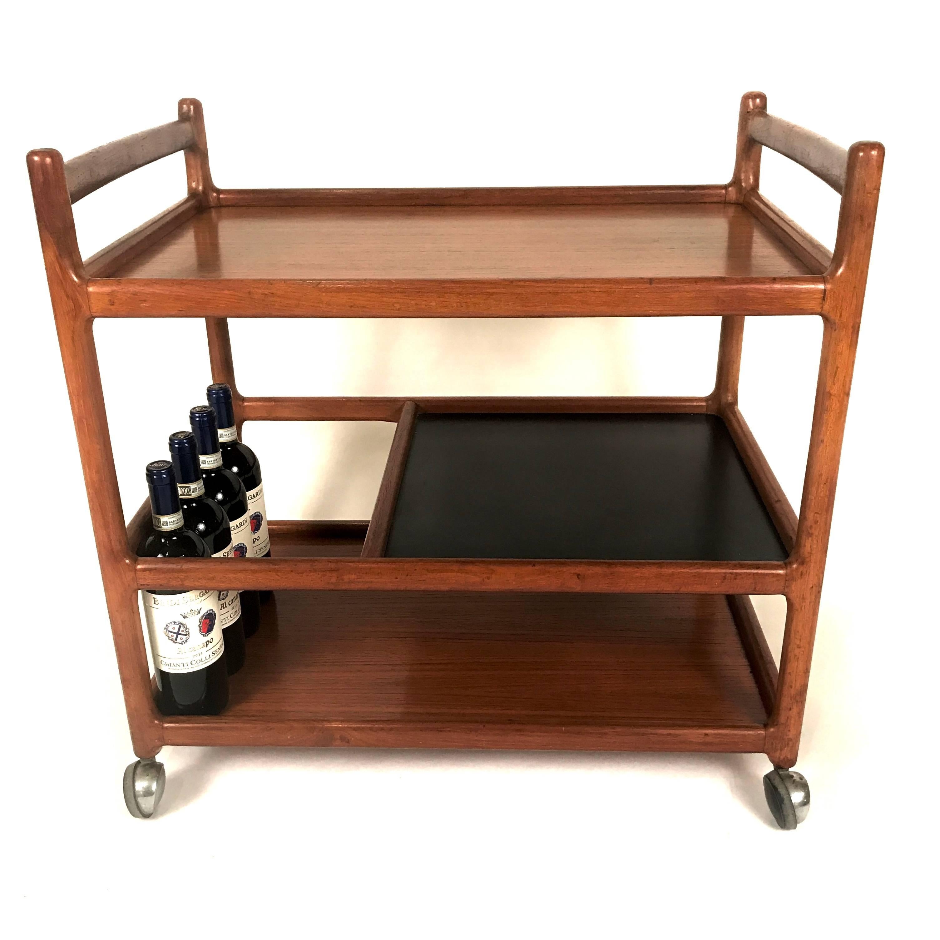 Danish Modern bar cart or trolley by Johannes Andersen for CFC Silkeborg in teak. Space for convenient bottle storage. Smooth rolling metal casters.