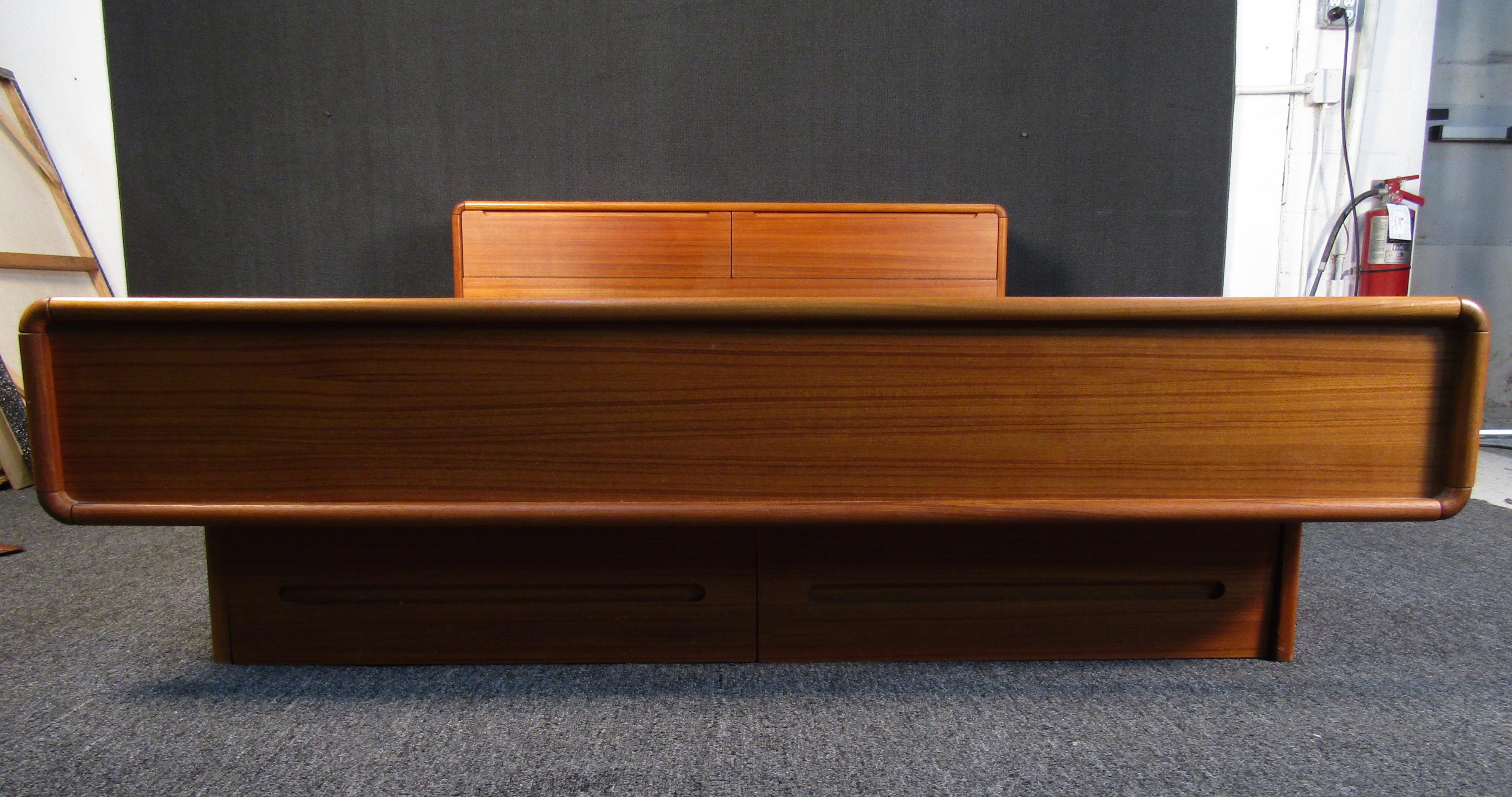 Mid-Century Modern style teak veneer bed frame featuring two drop down doors in the headrest for storage, two drawer underneath the bed for clothing, and slats for a mattress.

(Please confirm item location - NY or NJ - with dealer).