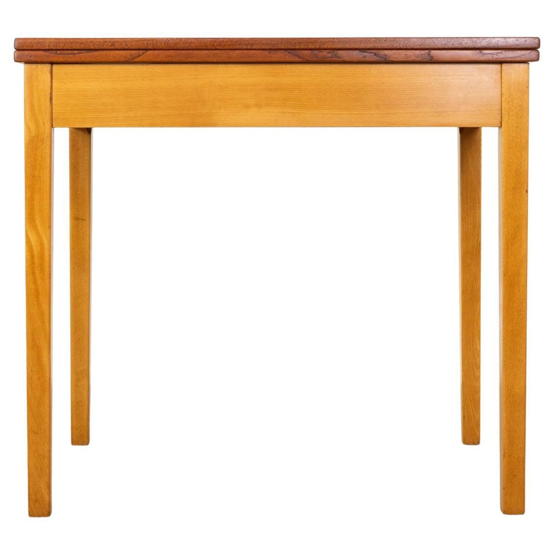 Teak & beech flip top table, circa 1960's. Versatile table with beechwood base and teak veneer top. Gleaming solid brass hinges allow the top to fold over and pivot, to increase surface area. Unique design, perfect for small spaces or for your games