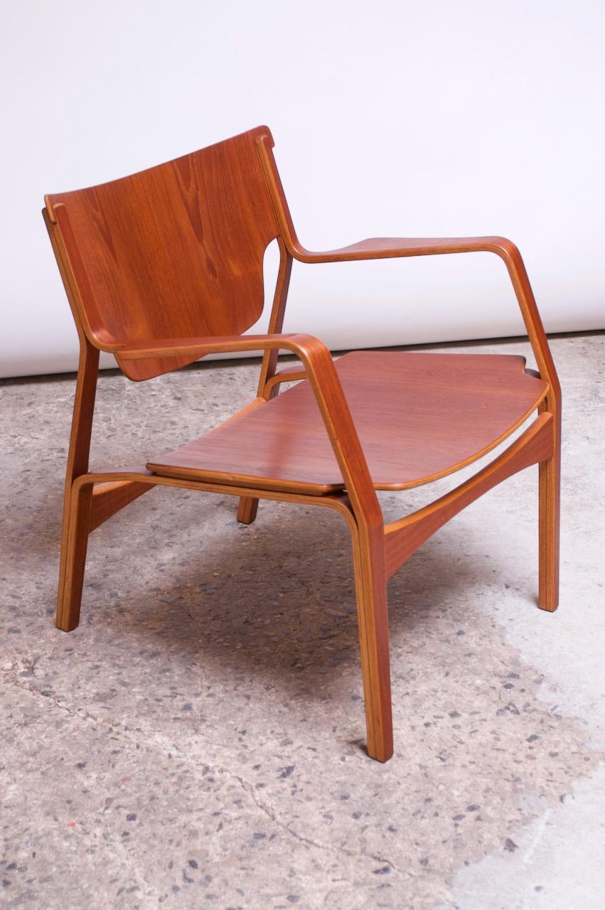 Unique Danish organic-form lounge chair composed of layers of laminated and bent wood finished with teak surfaces. Superior, modernist form with elegant, clean lines and curvilinear arms. Similar design to Peter Hvidt's 