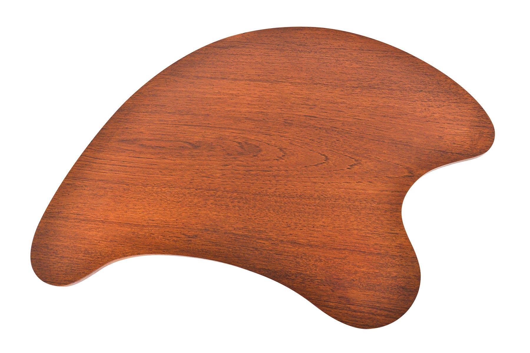 This Danish modern biomorphic shaped side table in teak is finished on all sides and offers organic lines. This rare find is a perfect companion piece for any lounge chair, sofa, or bedside. In excellent vintage condition.

  